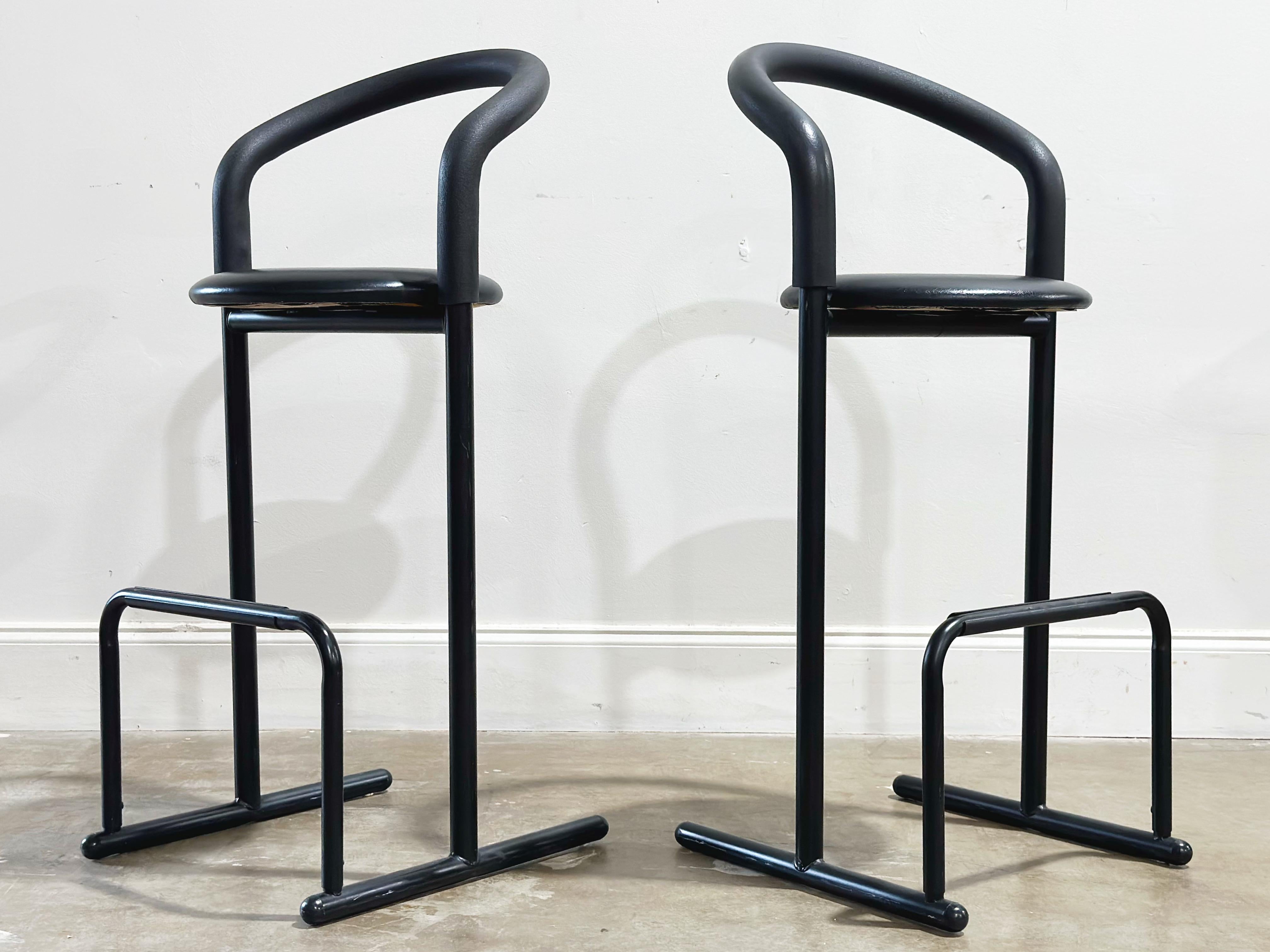 Pair of vintage post modern barstools by Les Industries Amisco - Canada circa 1980s. Bar height. Black metal frames with foam padded back/arm rests and black naugahyde seats. 
Excellent original condition - these stools look to have been hardly, if