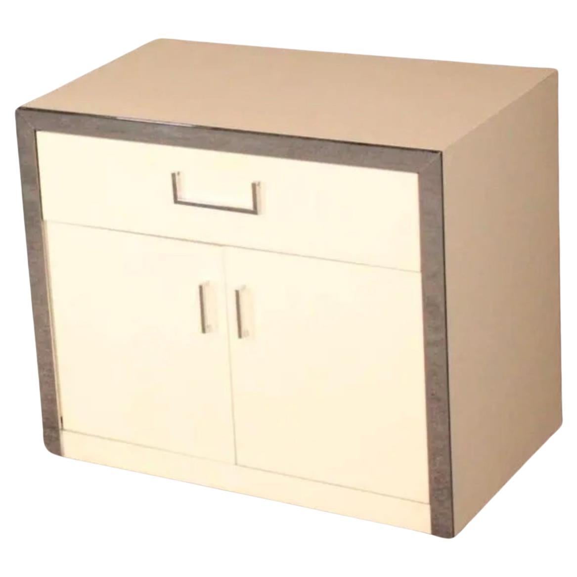 Pair post modern chrome and cream laminate nightstands. Nice Modern nightstands in white with polished chrome fronts and hardware. Labeled John Stuart. Has (1) upper drawer and (2) lower cabinet doors. Good vintage condition Ready for