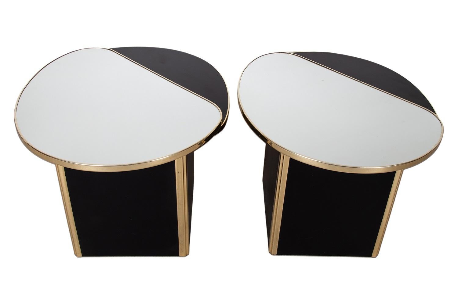 Voici une superbe paire de tables d'appoint postmodernes des années 1980. Chaque pièce présente un plateau en miroir sur une base cubique laquée noire, rehaussée de bordures dorées. La paire est conçue pour être un point focal frappant et une