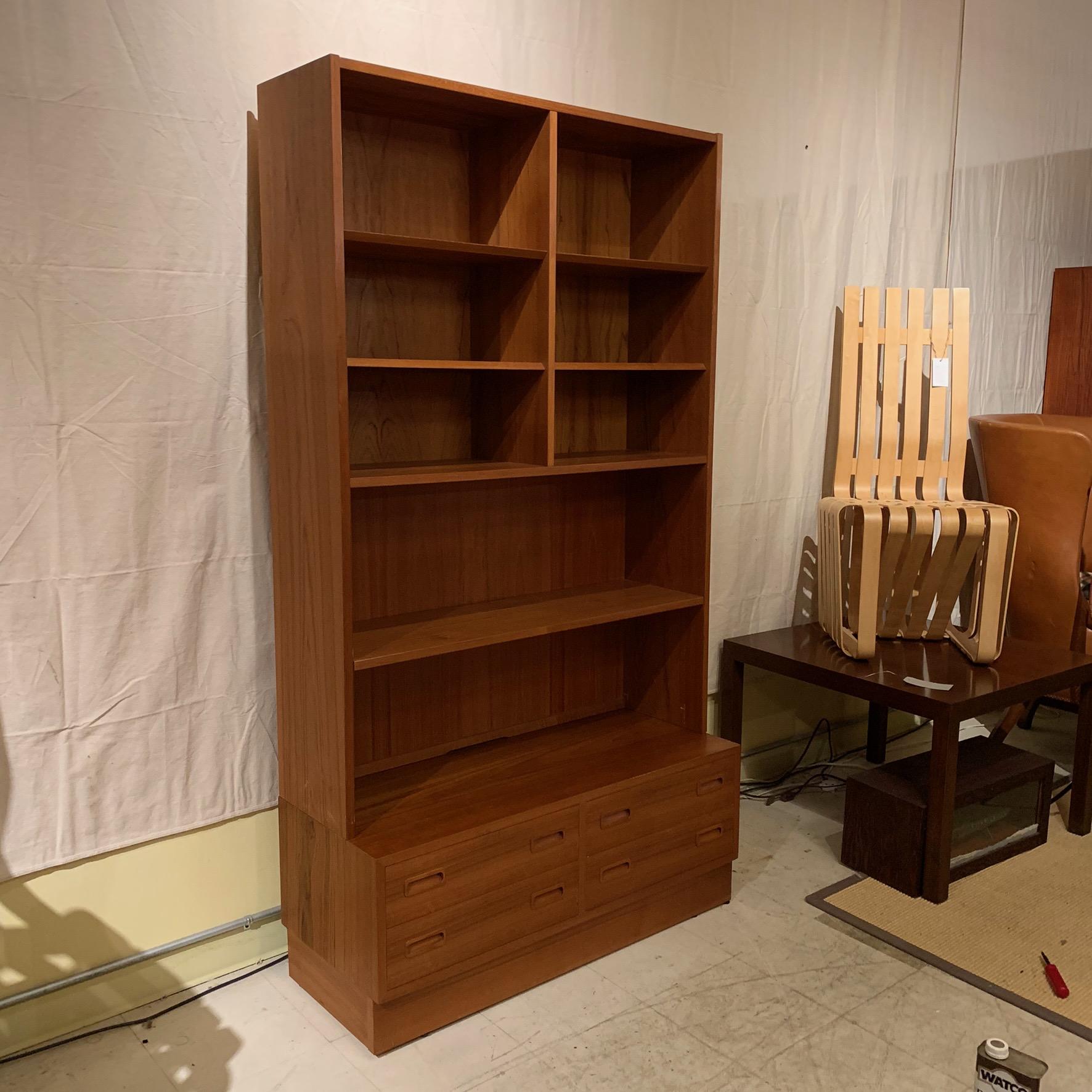 A versatile teak bookcase with five adjustable shelves and one fixed shelf. base consists of four drawers. Labeled Poul Hundevad and also has Danish Control label. 
 