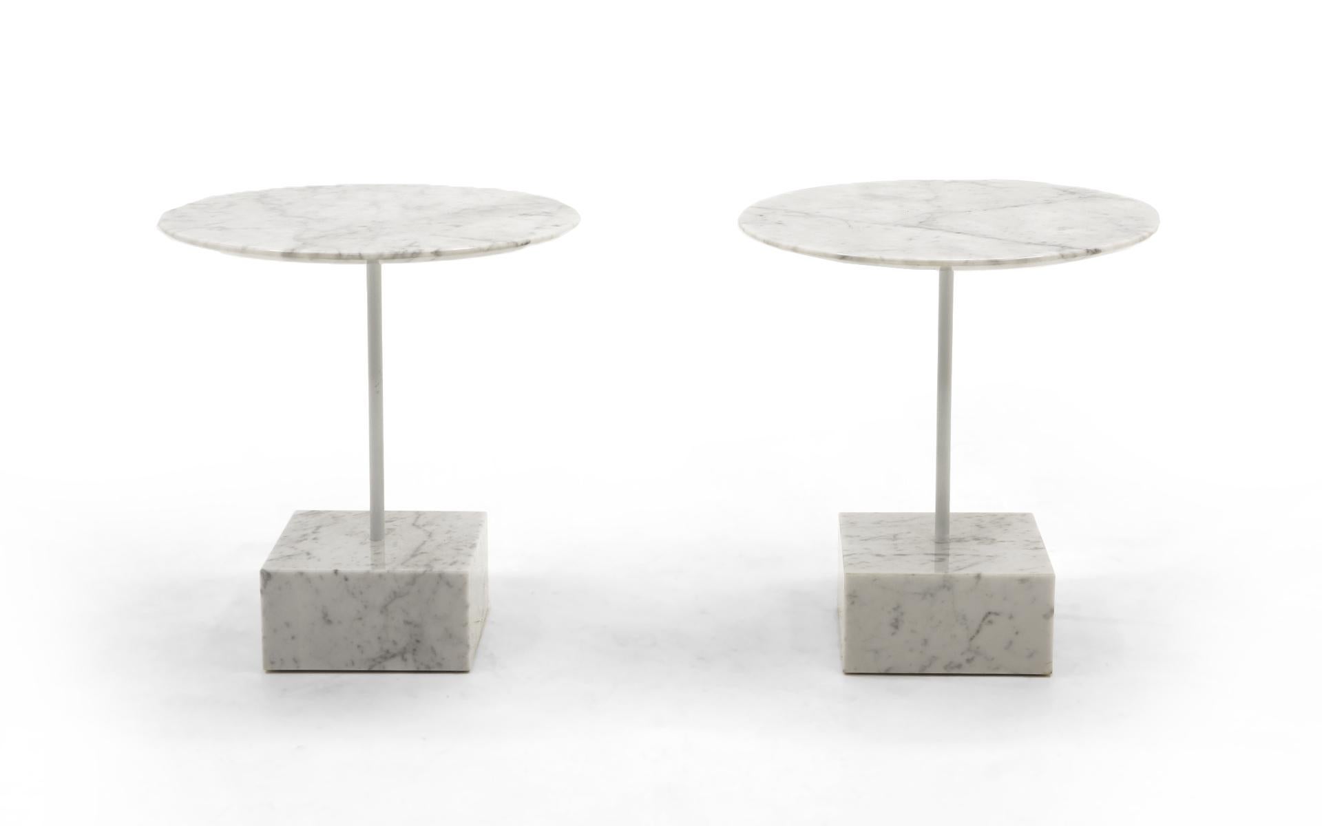 Pair of white marble side tables designed by Memphis Milano founder, Ettore Sottsass for Ultime Edizioni, Italy, 1990. Heavy square marble bases with beautifully beveled round marble tops. A lacquered steel support connects the top to the base. Very