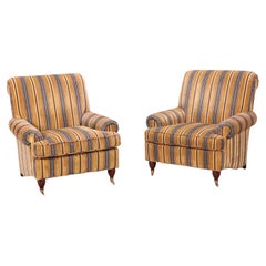 Pair quality upholstered club chairs in striped fabric having brass castors
