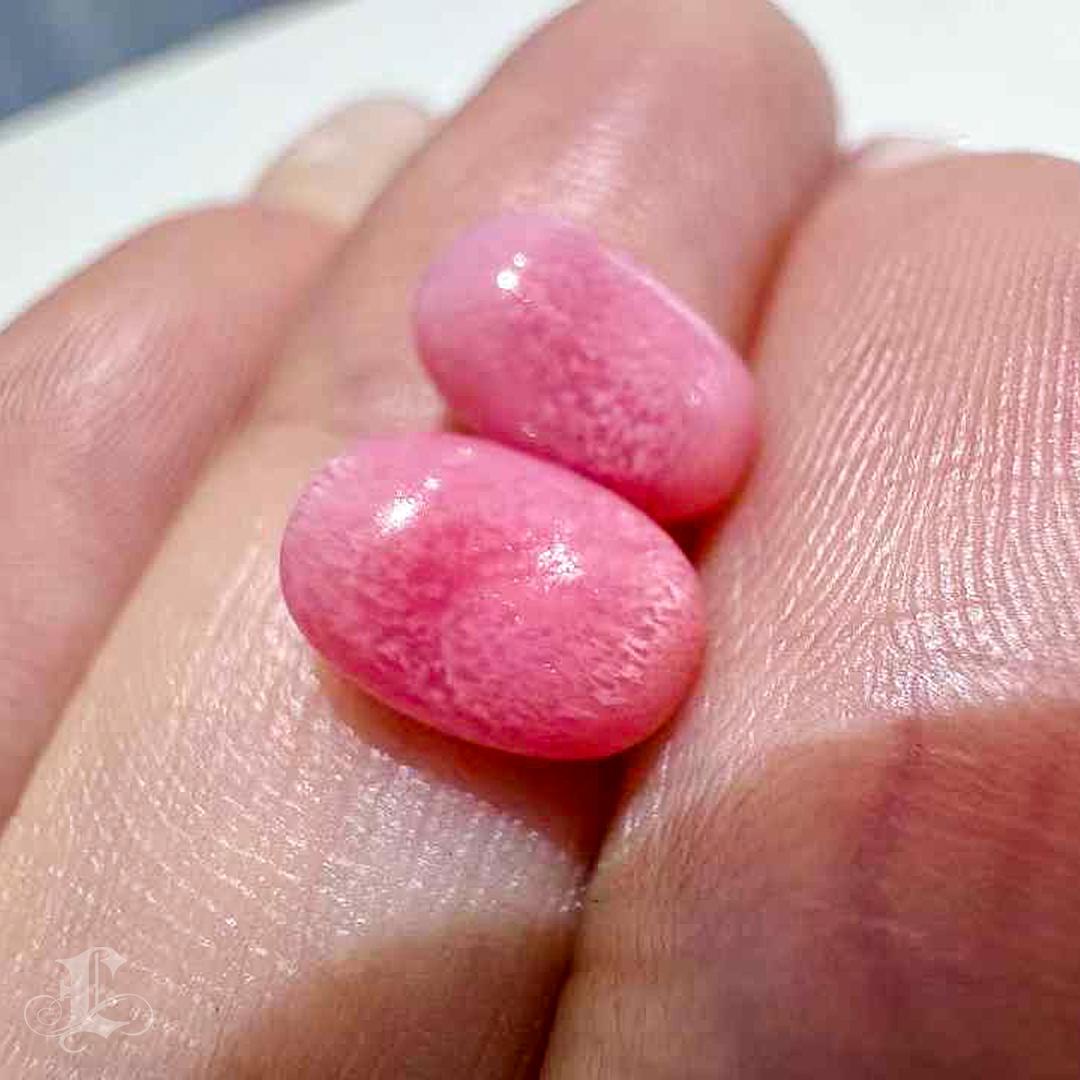 Dieses exquisite Paar Muschelperlen hat einen atemberaubenden flamingorosa Farbton und ist in Größe und Form perfekt aufeinander abgestimmt, was sie zu einer echten Rarität macht. Jede Perle ist mit komplizierten, unverwechselbaren flammenartigen