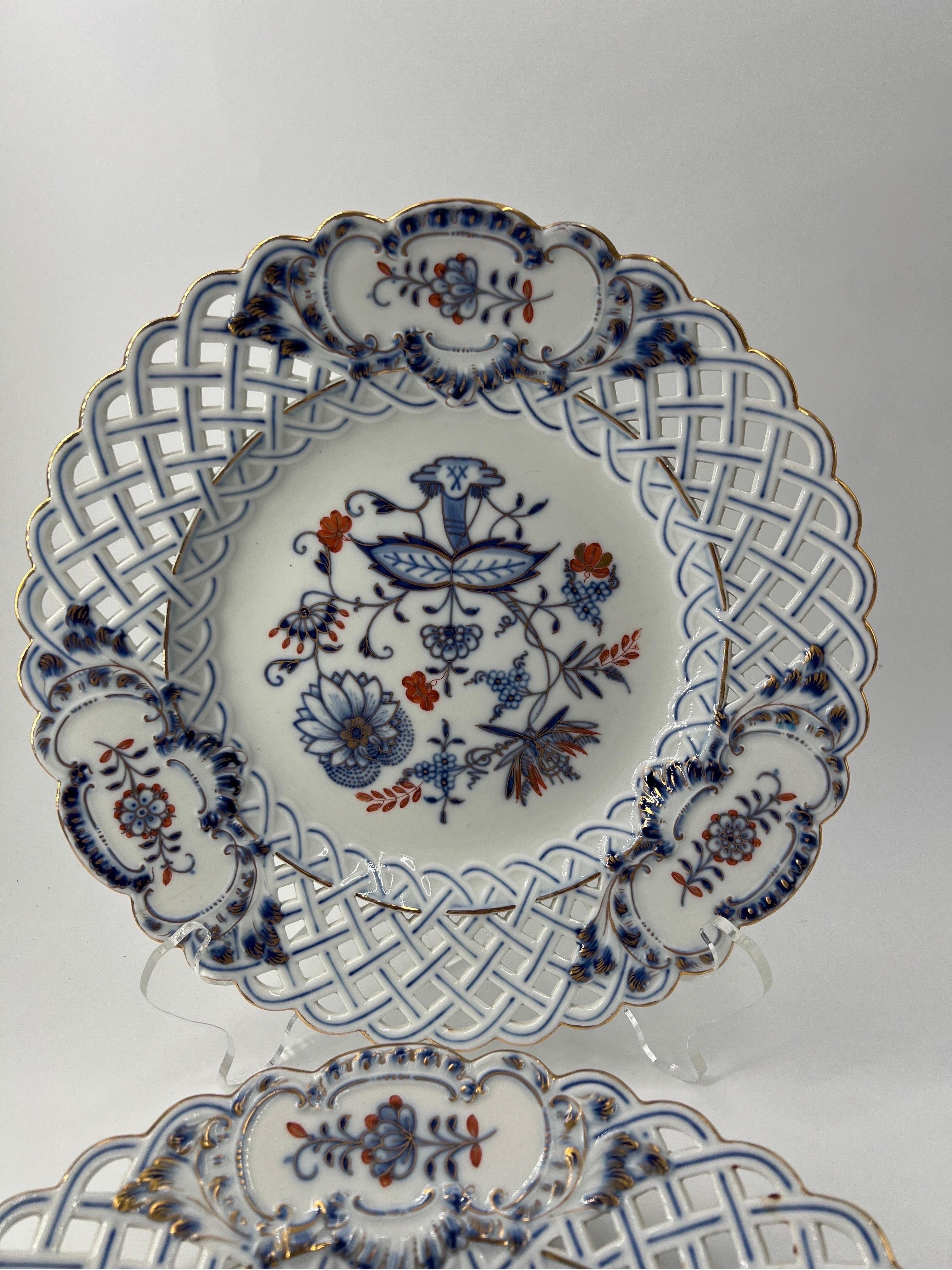 A beautiful pair of 11.25” Meissen porcelain plates in the rich blue onion pattern. The plates feature a fine reticulated border, floral decoration to center and marked to verso.