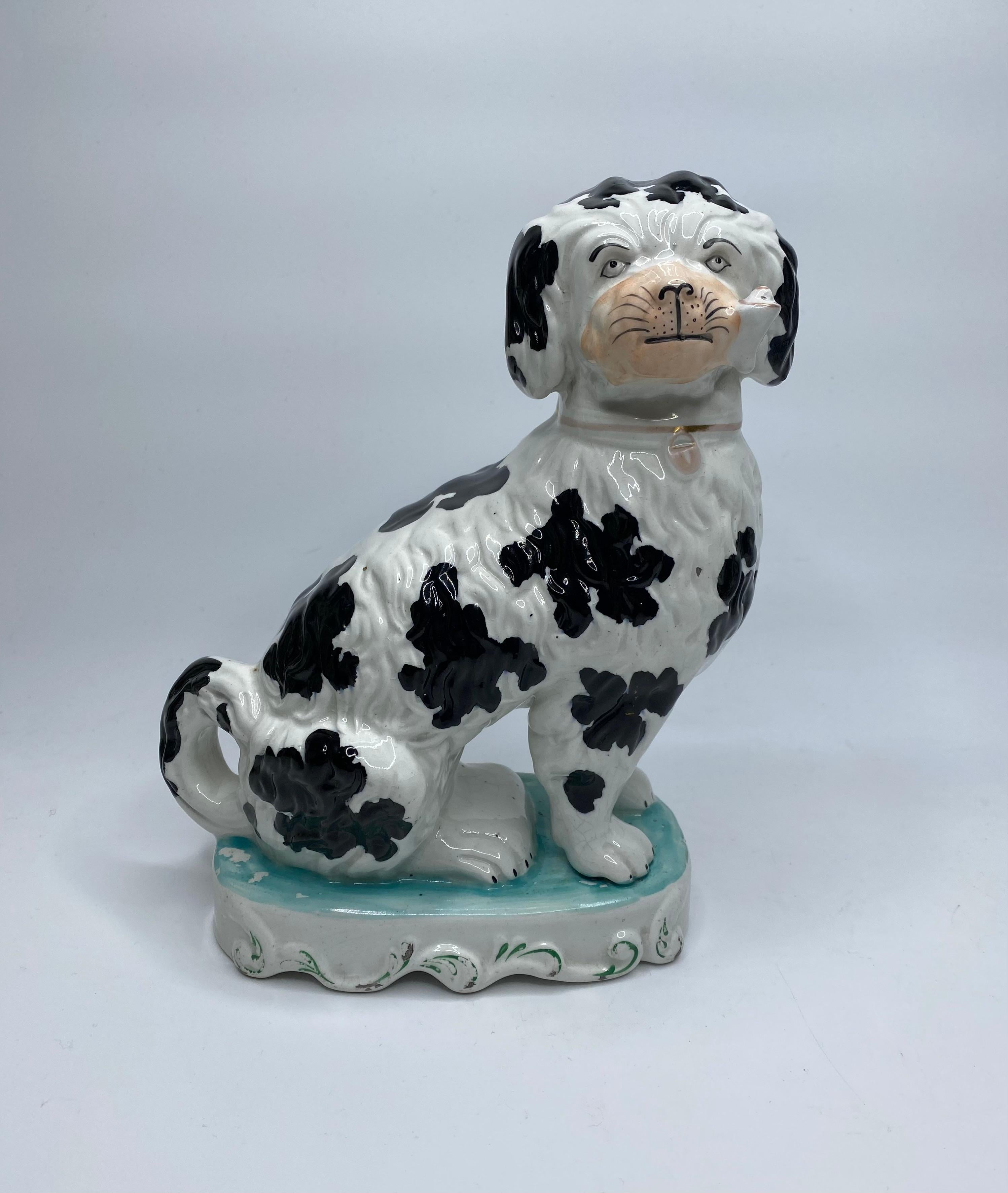 A rare pair of Staffordshire Pipe Smoking dogs, c. 1850.
The finely modelled seated dogs having separate front legs, and curled tails, whilst they puff on tobacco filled pipes. The deeply moulded fur, enhanced with underglaze black spots, and