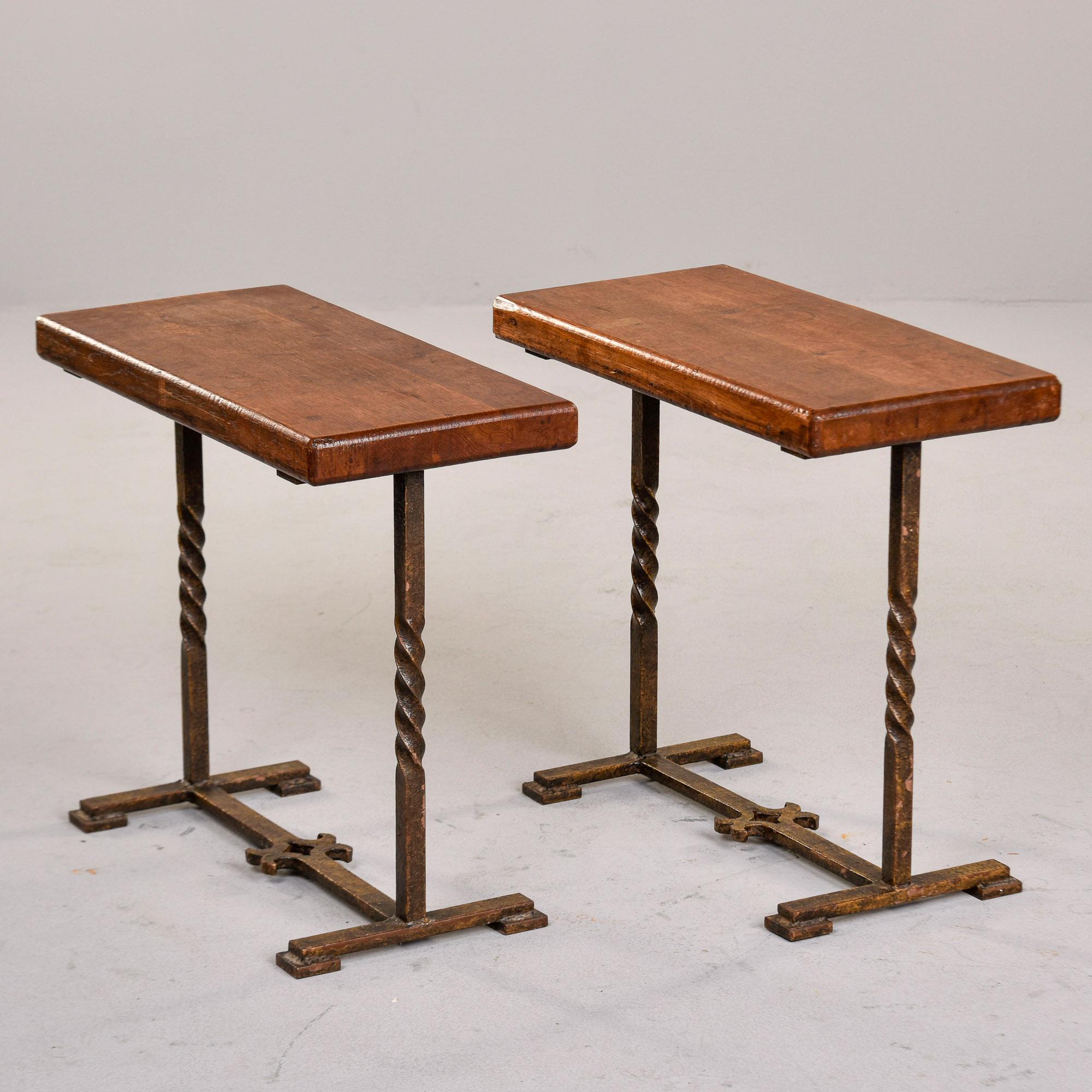 We found these tables in France, but believe they are of Spanish origin and date from the 1930s. This pair of small rectangular tables tops show honest wear - see detail photos -  and feature twisted iron legs with decorative ironwork on the base