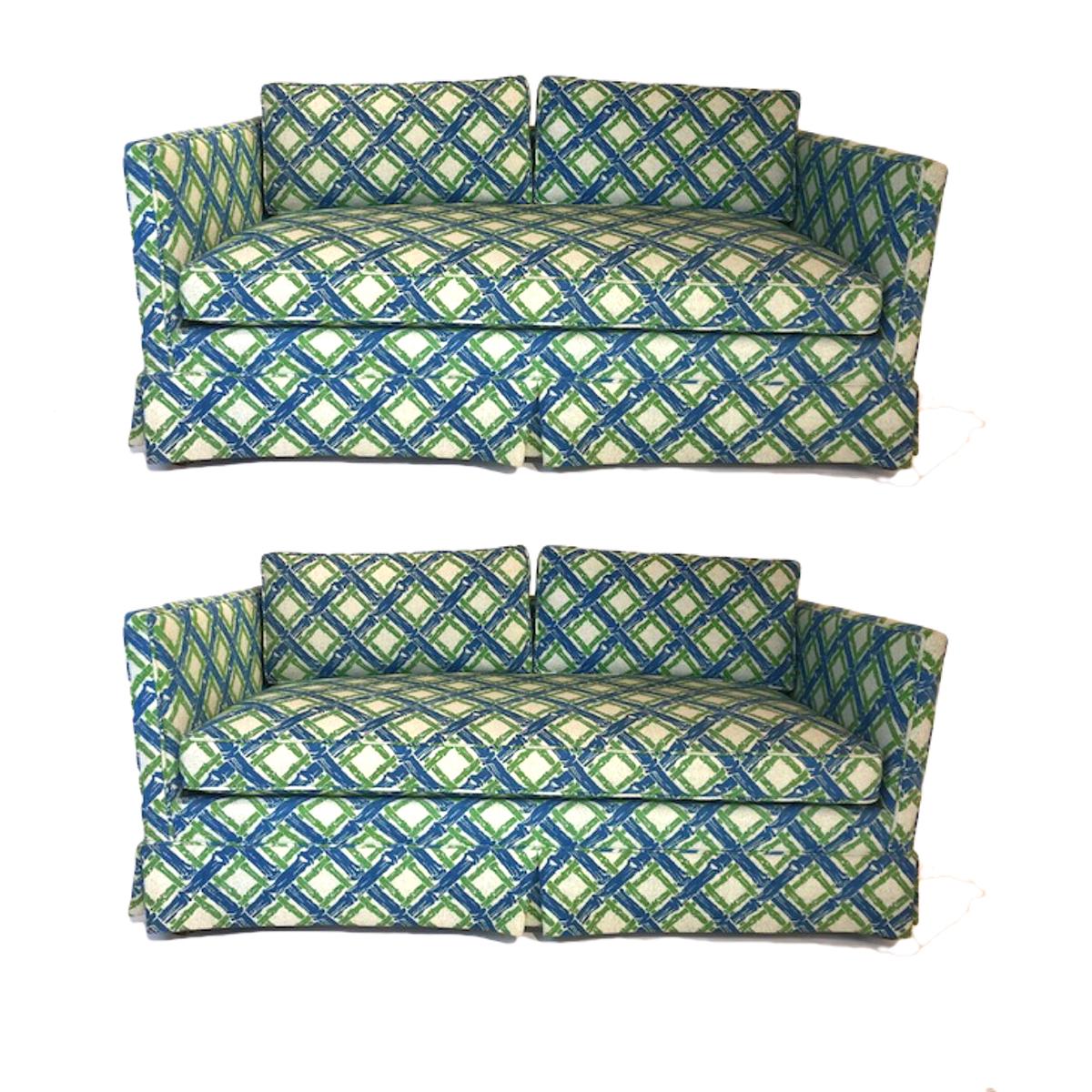 Stunning pair of 1950s Parson or Tuxedo style settees with luxurious heavy textured upholstery in a stunning lattice bamboo geometric pattern in a vibrant blue and green. These pieces are in very good condition. Under the skirt is square dark wood