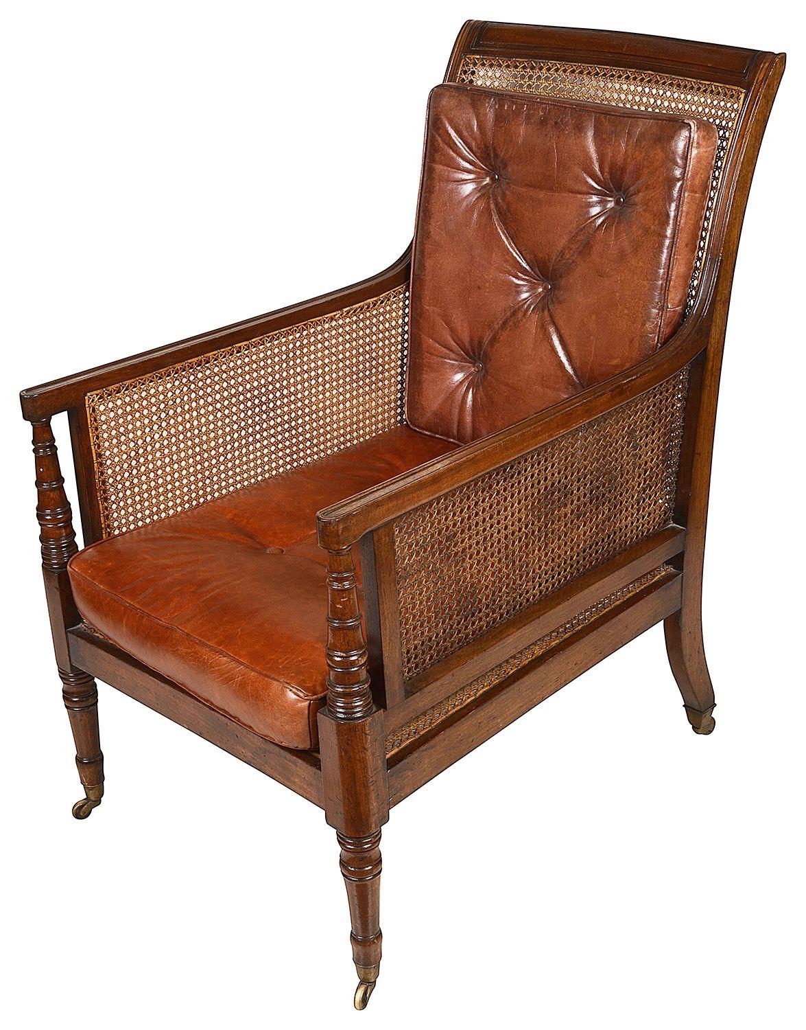A good quality pair of early 19th century Regency period Mahogany Bergere Library arm chairs. Each with leather buttoned cushions, caned back rest and arms, raised on turned tapering legs, terminating in brass cup castors, circa 1820.
c/c 60130