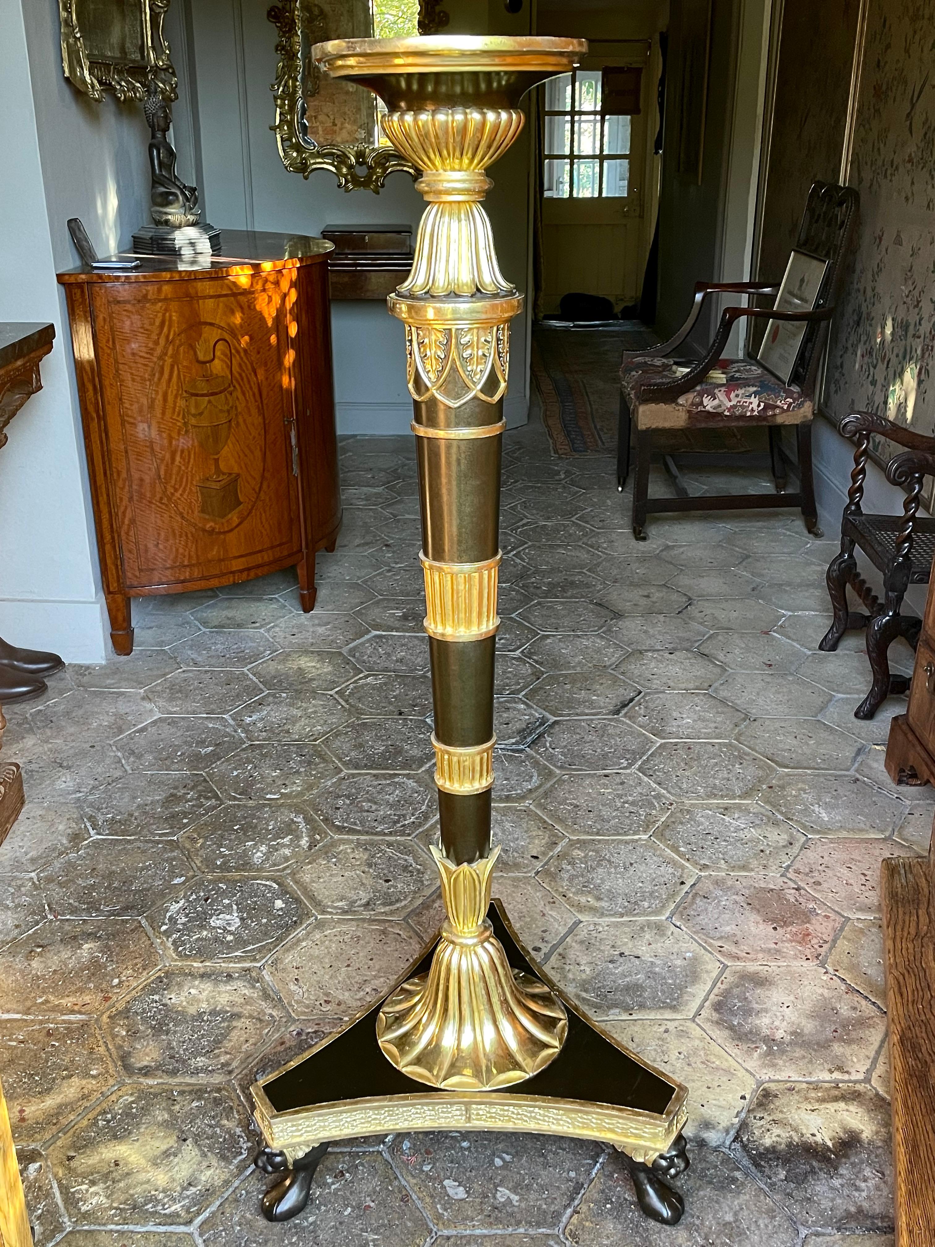A fine and rare pair of English Regency period torchères, or stands (or candle stands) in the manner of Thomas Hope. Circa 1810.

Both are raised on tapering simulated-bronze column supports with circular tops and fluted gilt collars, on