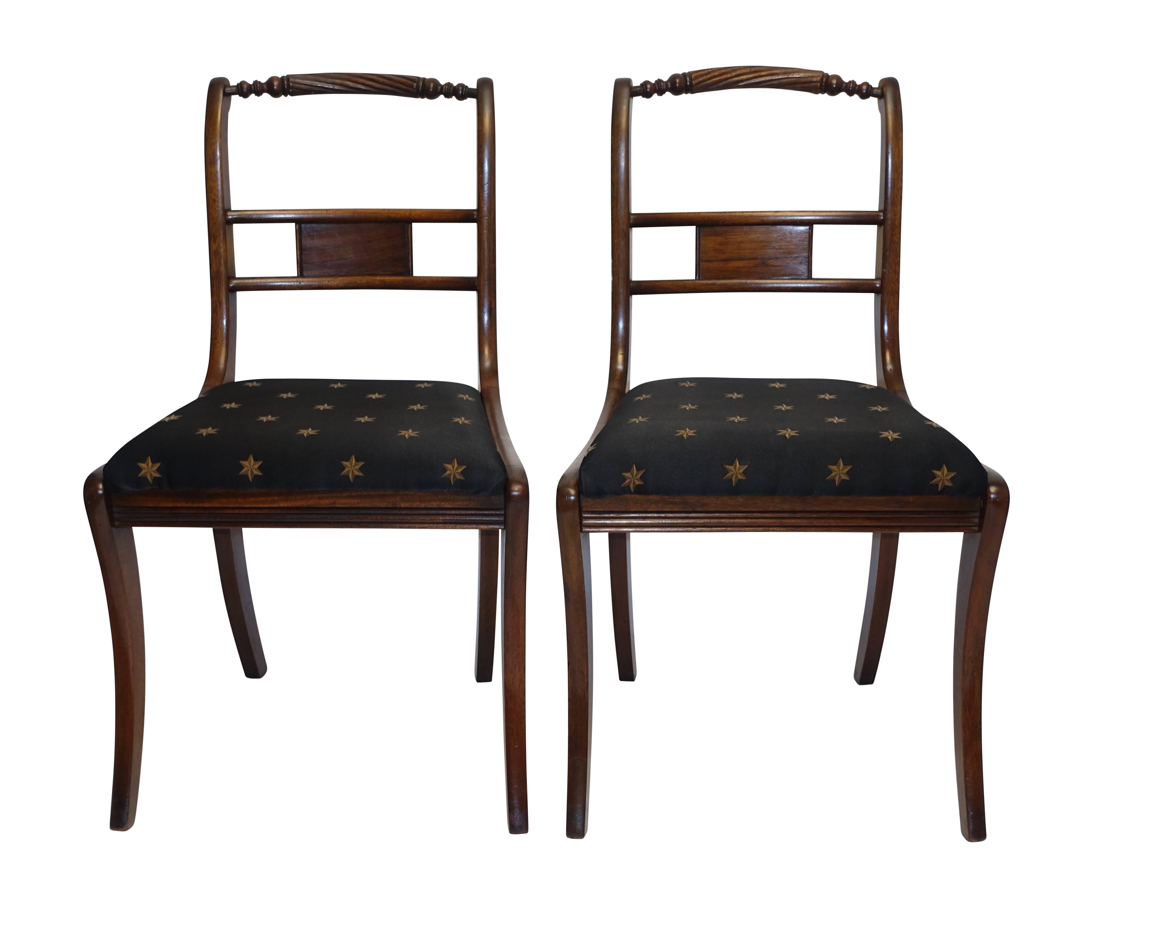 A very nice pair of rosewood dining side chairs with rope twisted and turned back rail, sitting on saber legs. England, circa 1820.