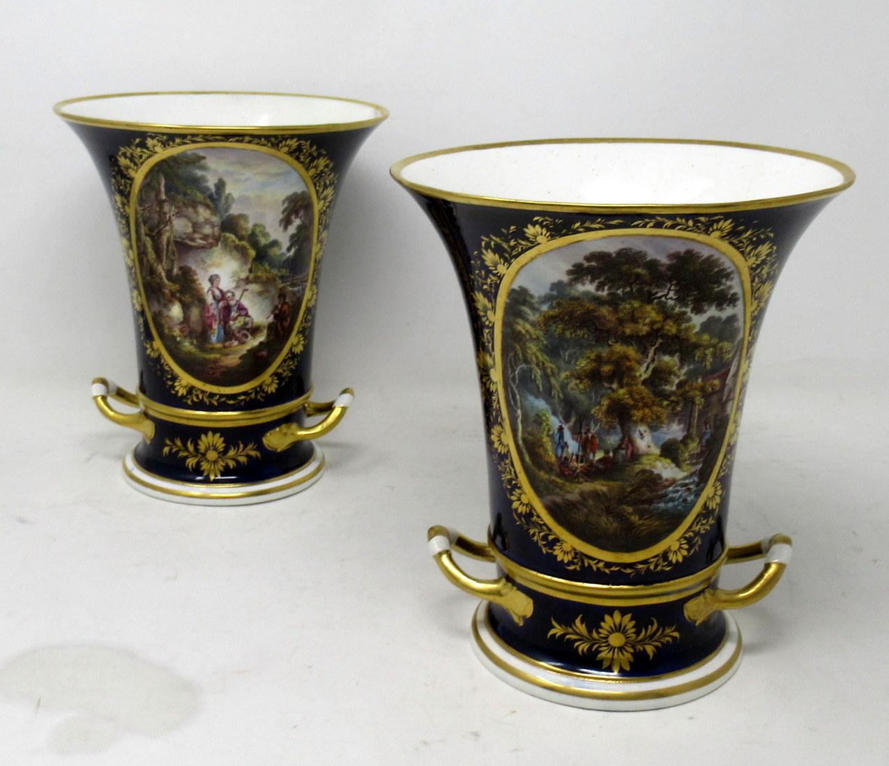 An exceptionally fine and quite rare large pair Royal Crown Derby hand painted twin handle urns of Campana outline, early nineteenth century. 

Each main central oval reserve with lavish gilt surround exquisitely hand painted depicting a pastoral