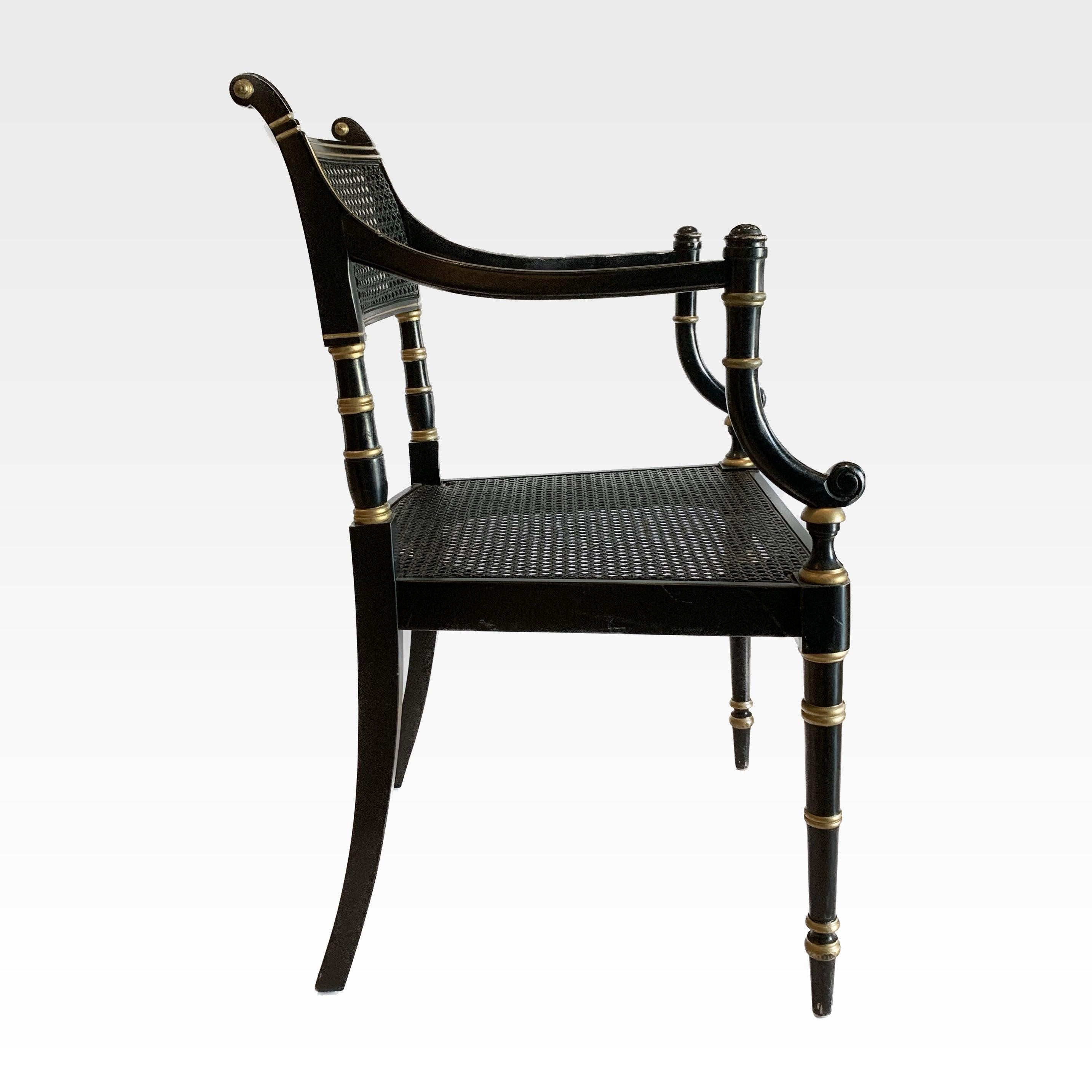 Pair of 20th Century ebonized and gilt Regency style cane chairs with newly upholstered loose seat cushion in ticking. 

These chairs are professionally upholstered and are also available C.O.M. with a quick turnaround. Press inquire for