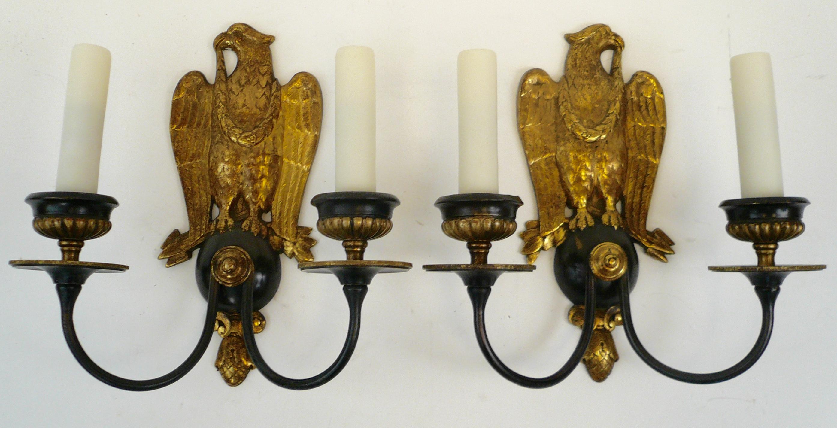 This handsome pair of gilt and patinated bronze two-light sconces feature mirror image eagles, and pinecone finials. They are newly re-wired, and ready for use.