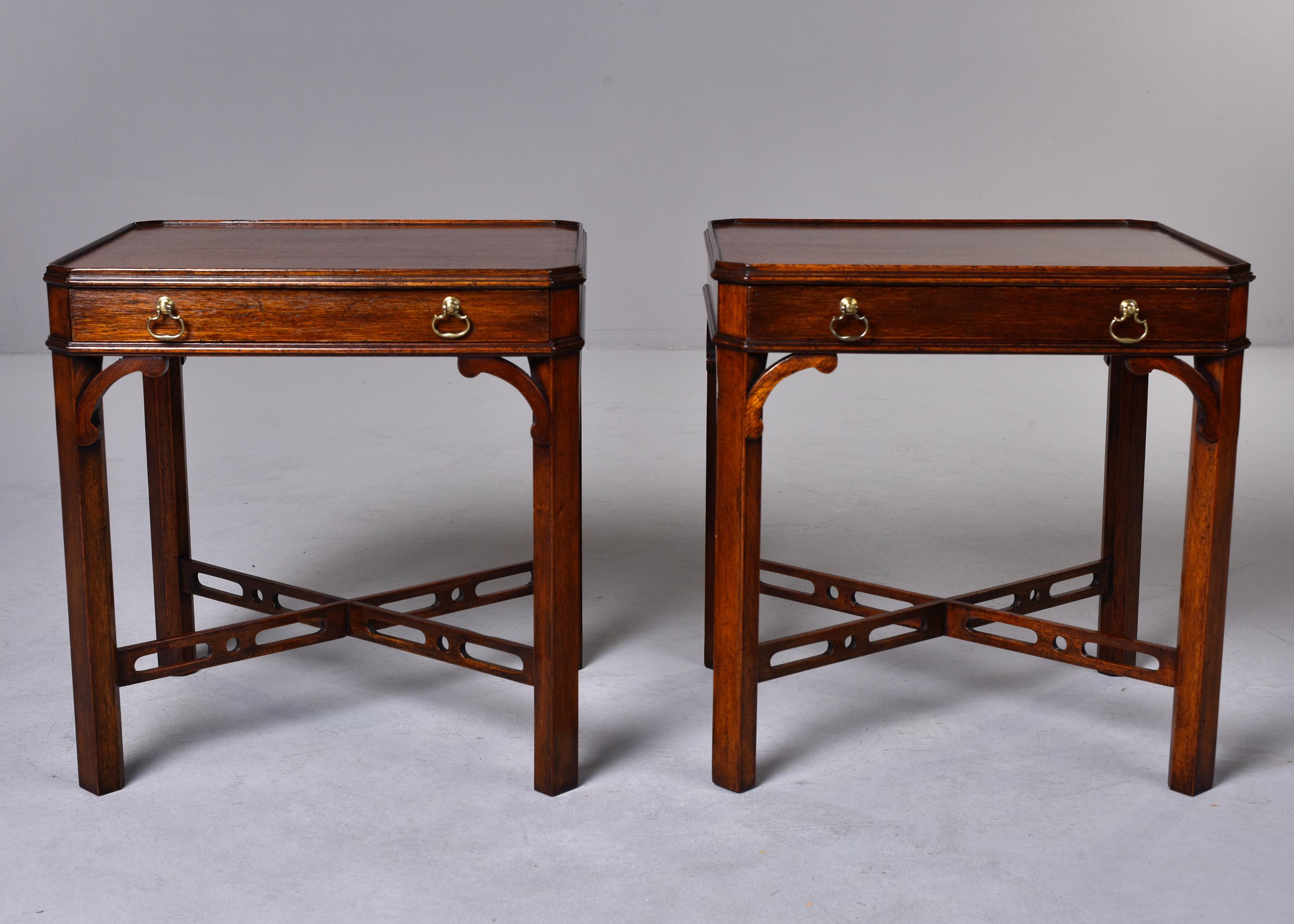 Found in England, this pair of Regency style circa 1920s mahogany side tables each have a single functional drawer and open work x-form stretchers. Unknown maker. Very good antique condition.
