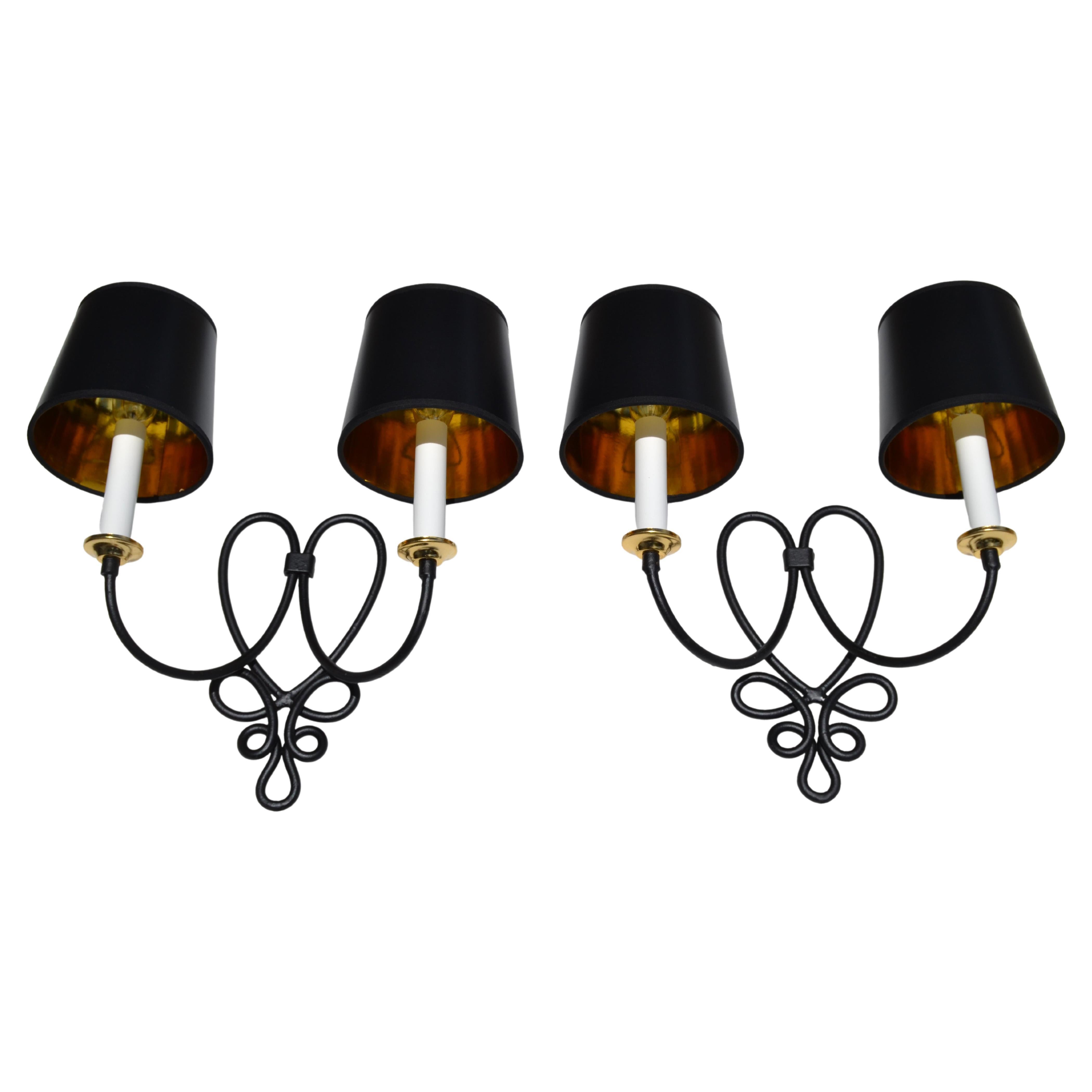 Art Deco pair of wrought iron 2 light sconces, wall lamps in black satin finish.
Made in France circa 1950.
US Rewiring and each Sconces takes 2 candelabra Light Bulbs with max. 40 watts.
Projection of the wall: 7 inches.
Width without the