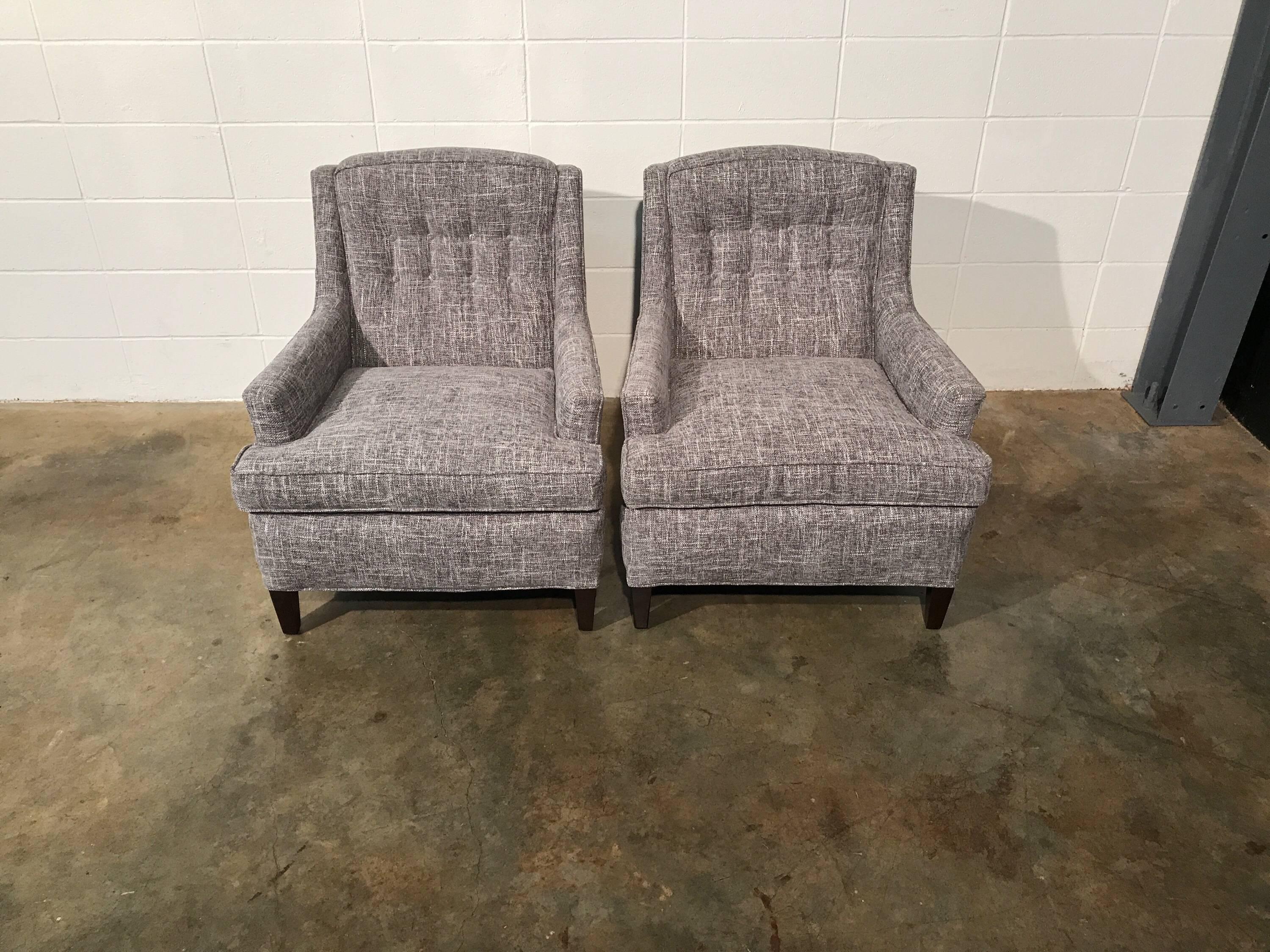 Pair of fully restored Mid-Century Modern lounge chairs. All new gray upholstery and refinished legs bring these beauties back to life. The timeless design will blend with nearly any style in any space. Extra buttons included
 The chairs have no