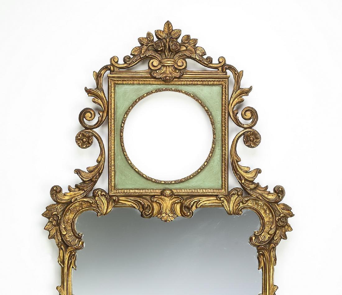 Pair of Rococo Revival style paint decorated wood mirrors, early 20th century, each have a carved rose bouquet crest above a square celadon tablet centering a circular mirrored frame flanked by carved 's' scrolls and 'C' scrolls, surmounting a