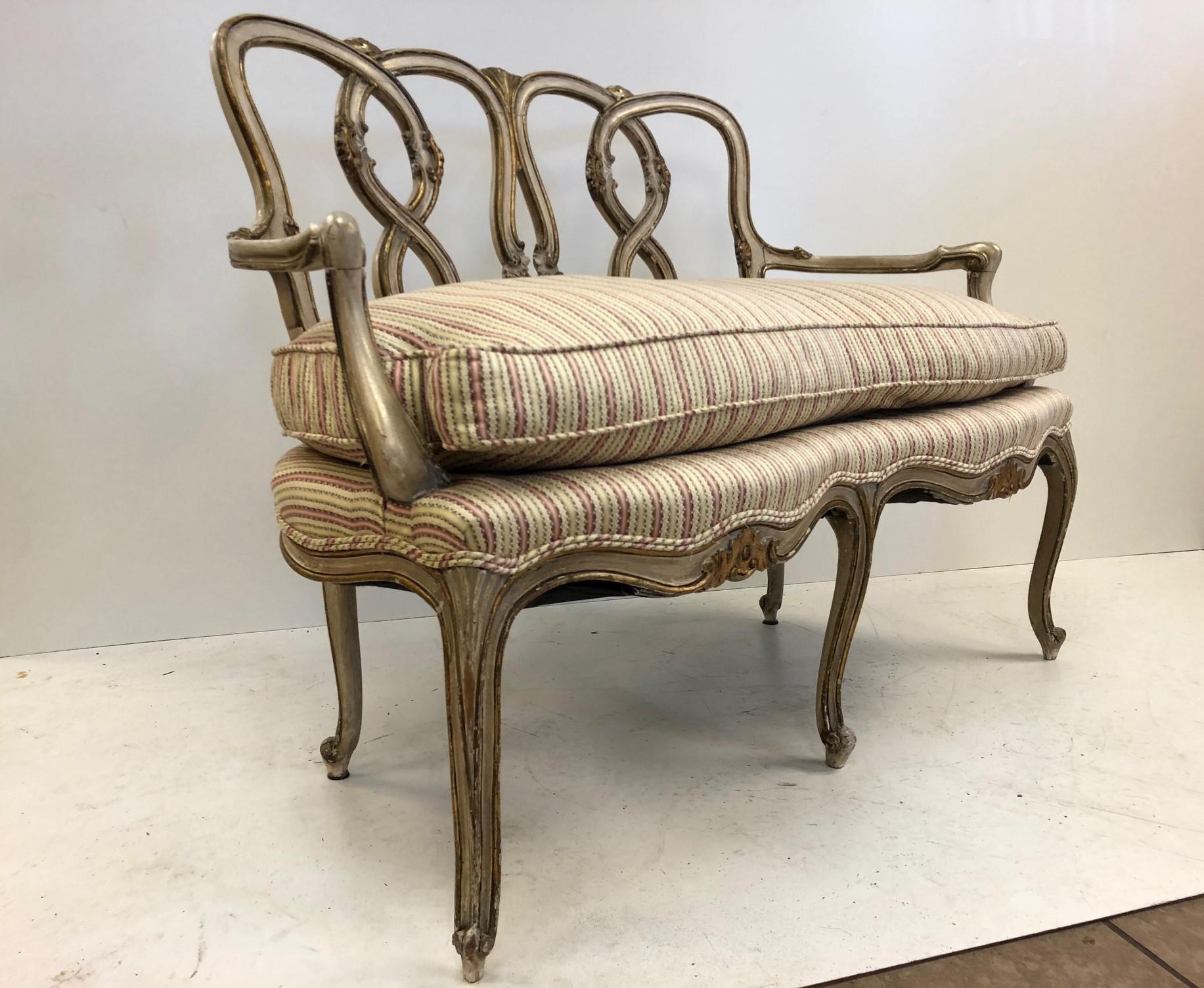 Pair of Rococo style parcel-gilt painted settees. Original seat upholstery and down filled.