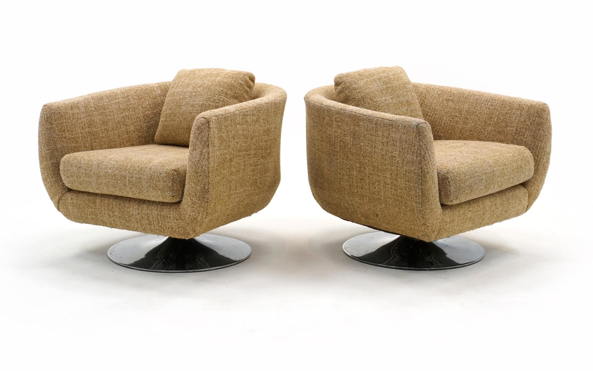 Two barrel back even arm swivel lounge chairs in the style of Milo Baughman for Thayer Coggin. Very well constructed, sturdy and comfortable, the chairs rest on cast aluminum tulip bases. We expect the buyer will want to reupholster these chairs so