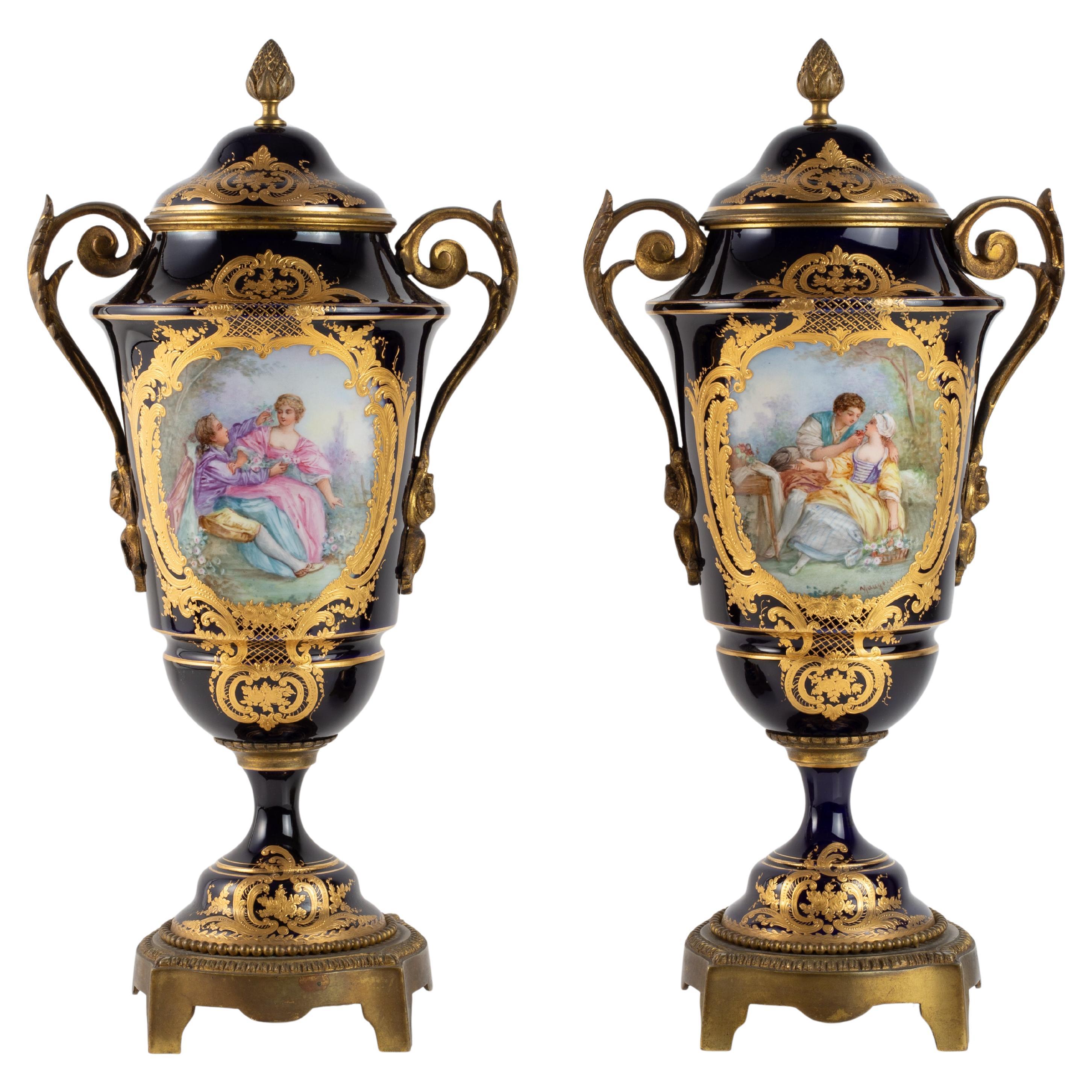 Coppia di vasi coperti in porcellana di Sèvres blu reale e montati in bronzo con scena Watteau in vendita