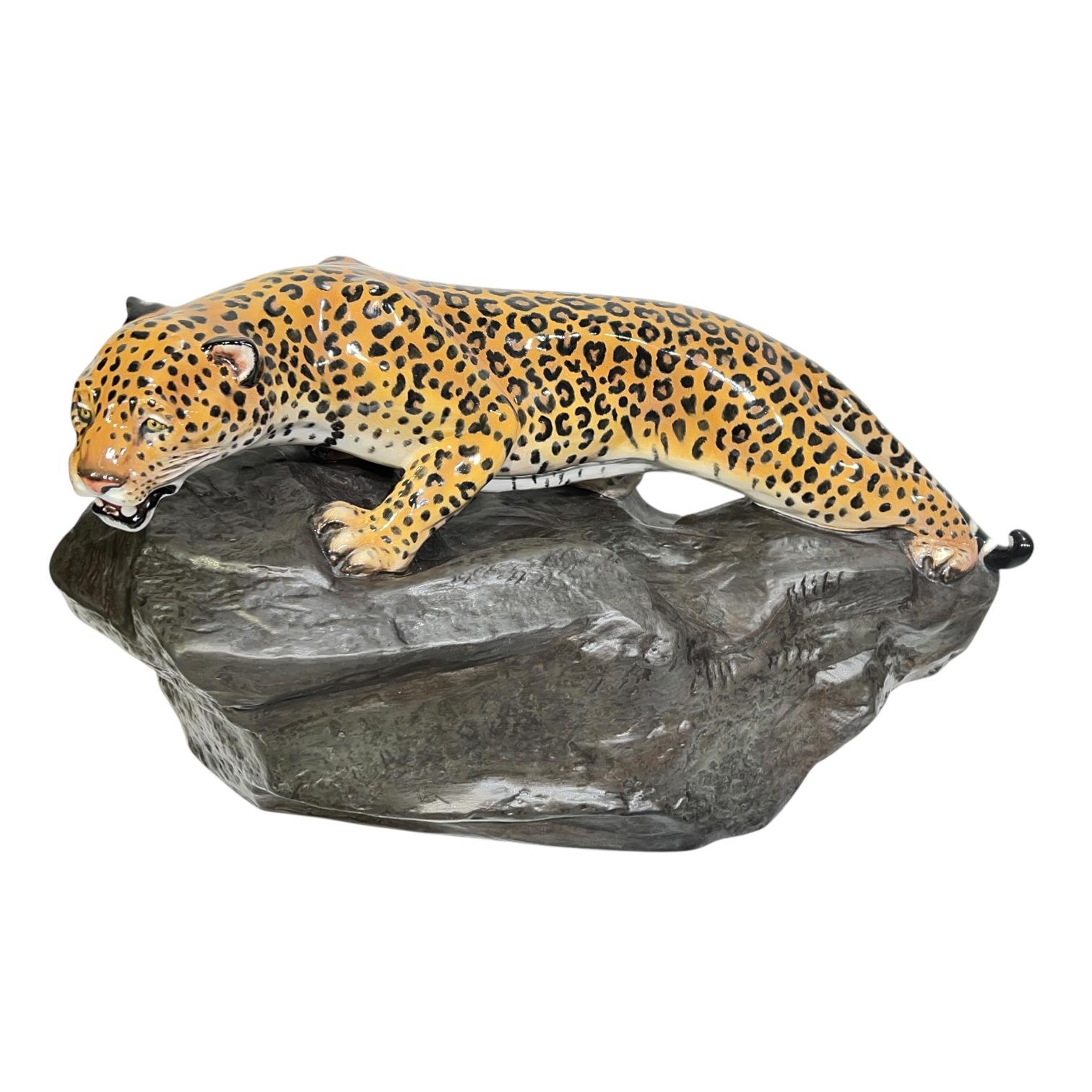 Pair of polychrome glazed porcelain figures of leopards standing on a rock from Royal Doulton, dating from the 1970s.  Each 9 inches tall, 16 1/2 in wide and 7 1/2 in deep, and in excellent condition.