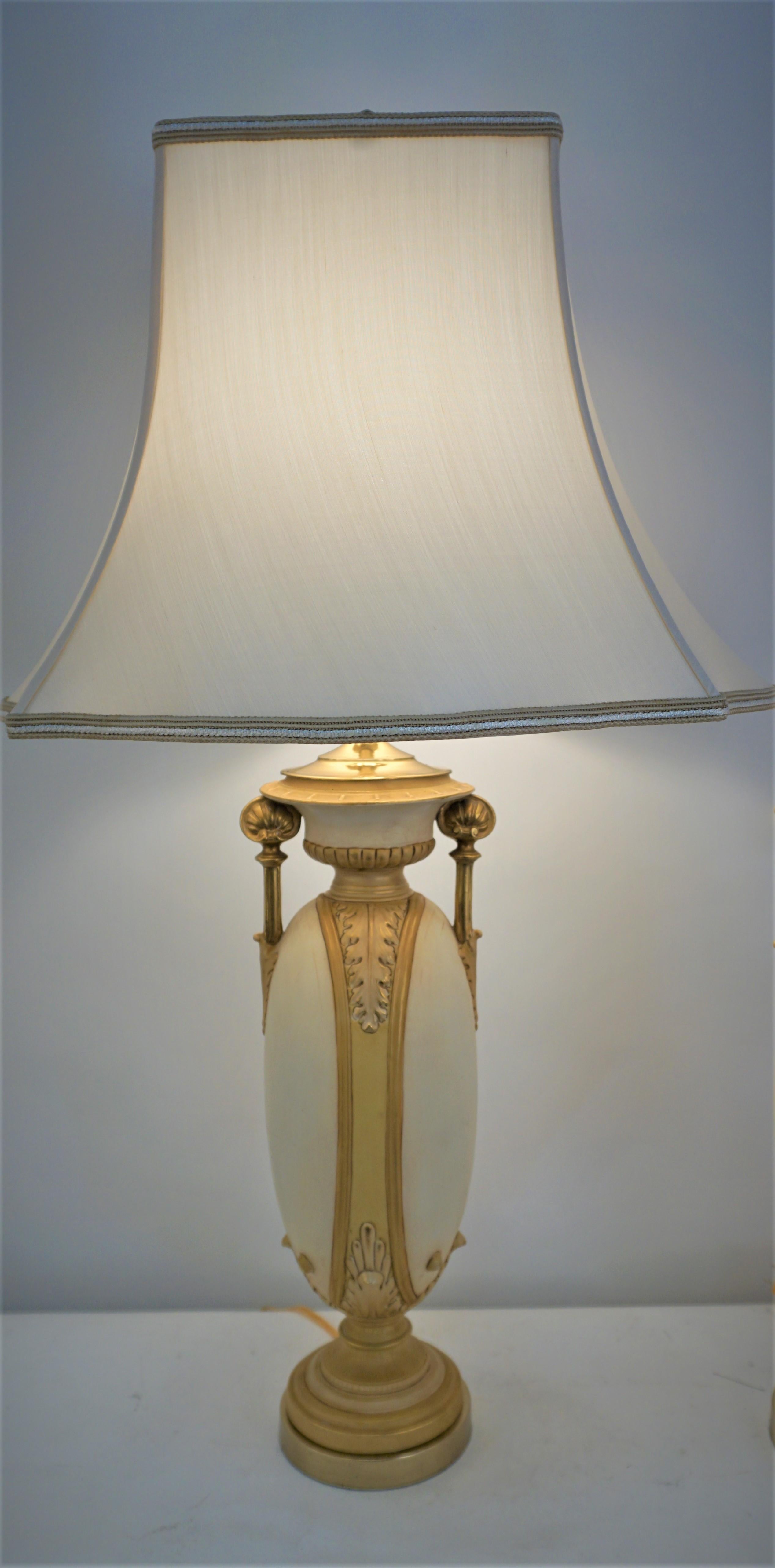 Pair of classic design porcelain vases that have been customized as table lamps and fitted with silk lamp shades.
Measurement includes the lampshades.