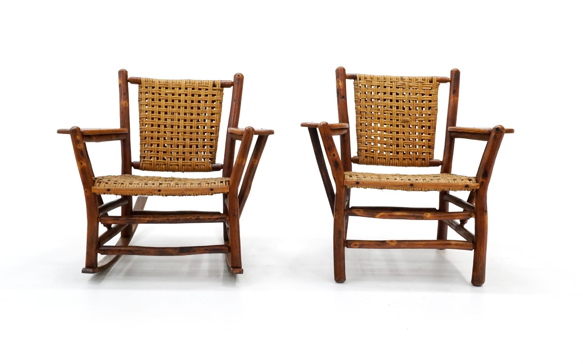 Complimenting pair of old hickory armchairs. One is a lounge chair and the other a rocking chair. The solid hickory frames and woven wicker seats and backs are in very good condition both cosmetically and structurally. No holes or tears in the