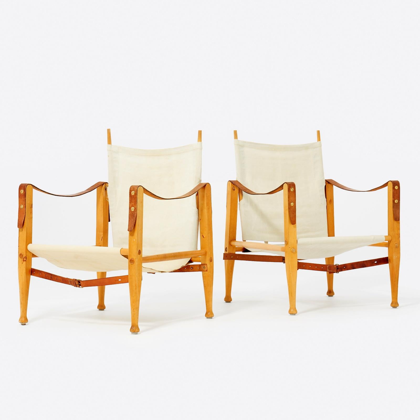 Lovely pair ‘Safari’ model 4700 easy chairs by Kaare Klint for Rud Rasmussen, Denmark 1950s. This set features a frame made out of stained oak with leather straps. Frame in oak with seat, back, and armrests in canvas. 
58x58x80 cm.
The model was
