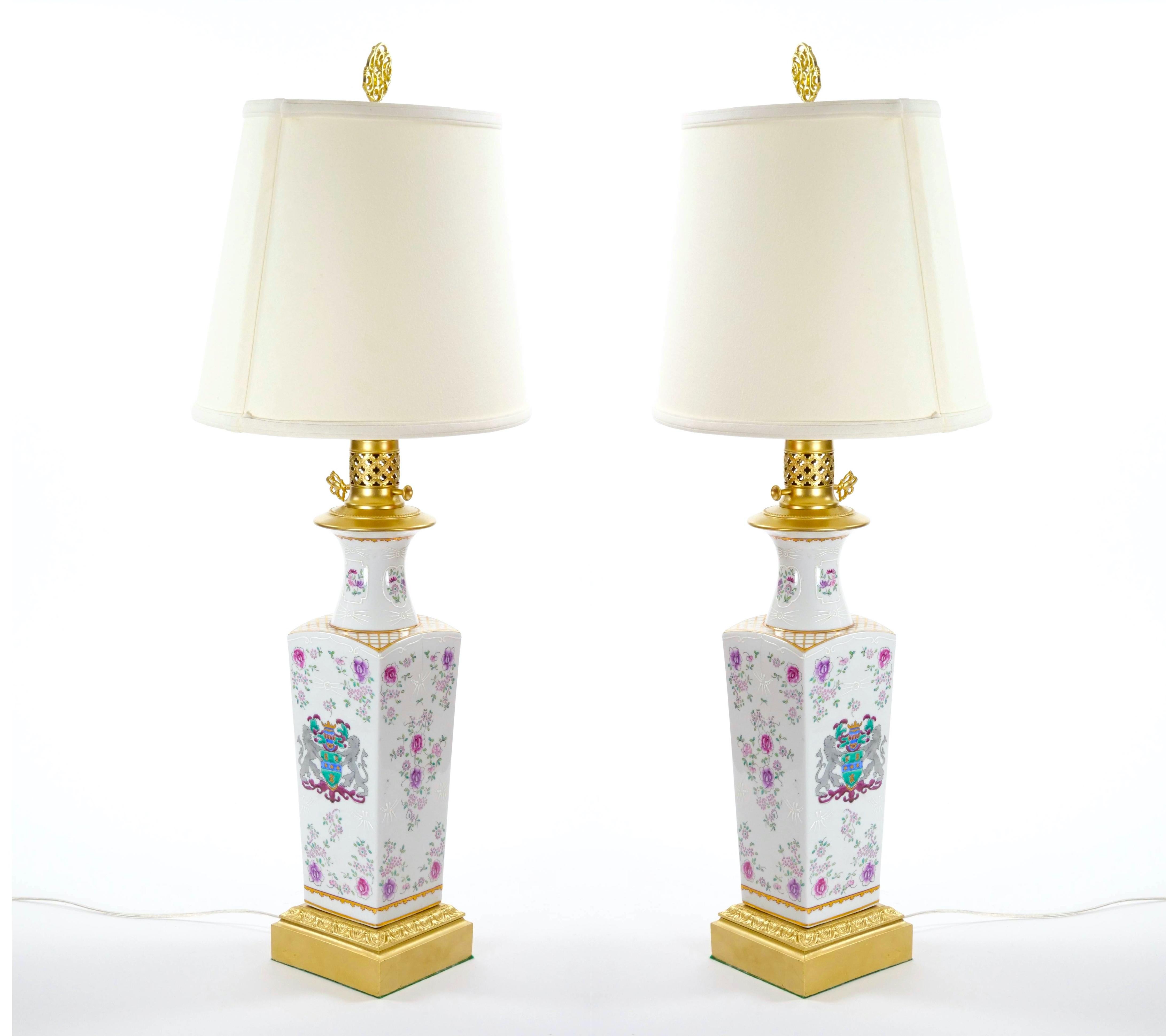 Questa splendida coppia di lampade da tavolo Samson presenta decorazioni floreali e fogliate dipinte a mano su corpi in porcellana con splendidi dettagli in oro dorato. Ogni lampada è realizzata in un'elegante forma di urna a colonna, con un collo