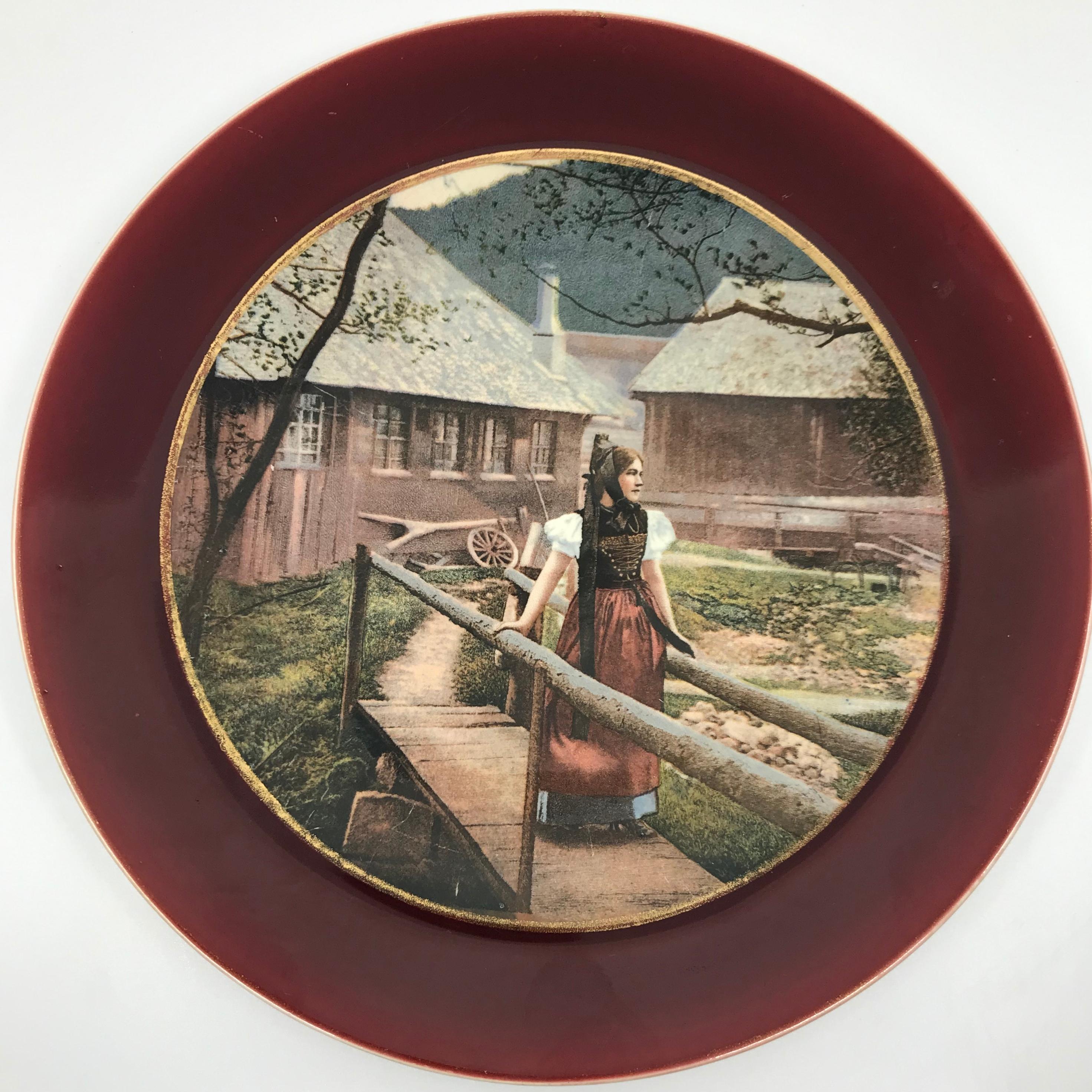 Pair of Sarreguemines Strasbourg plates. Pair of dark wine red and gilt bordered cabinet plates with colored transfer photos of the theatre of Strasbourg and girl in local dress, with markings for Sarreguemines. Originally retailed by Charles F.