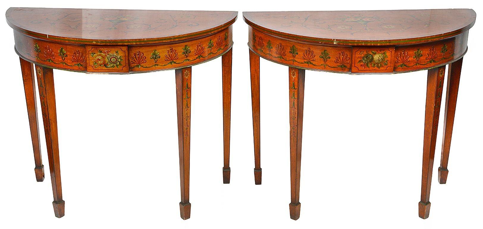 A very decorative pair of late 19th century Sheraton revival Satinwood demi lune console / side tables. Each with wonderful hand-painted classical decoration of flowers and scrolling foliage. Raised on square tapering legs, terminated in spade