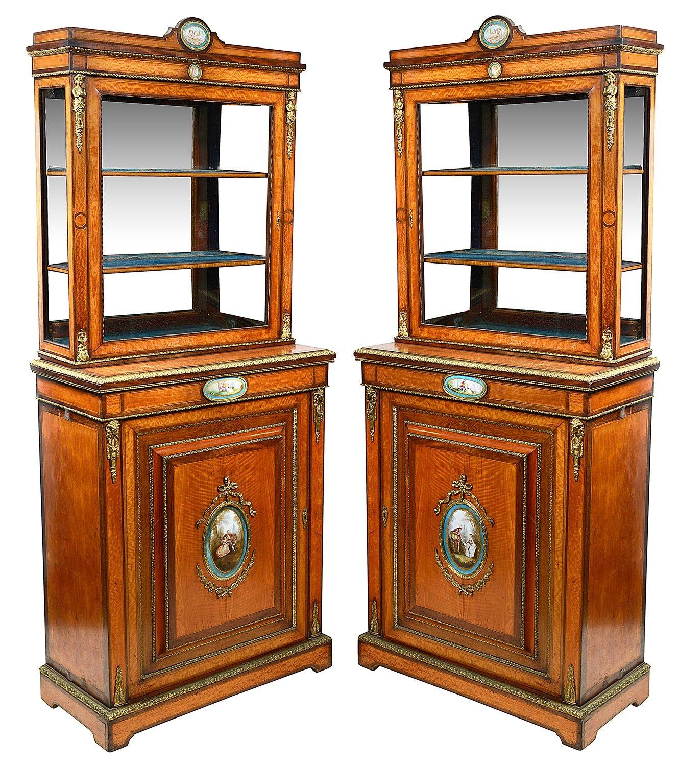 Ein feines Paar Satinholz-Pfeilerschränke aus dem späten 19. Jahrhundert, mit  Ormolu-Beschläge und kompliziertes Design. Jedes Schränkchen ist mit handbemalten Porzellanplaketten im Sèvres-Stil versehen, die romantische Szenen von Liebespaaren