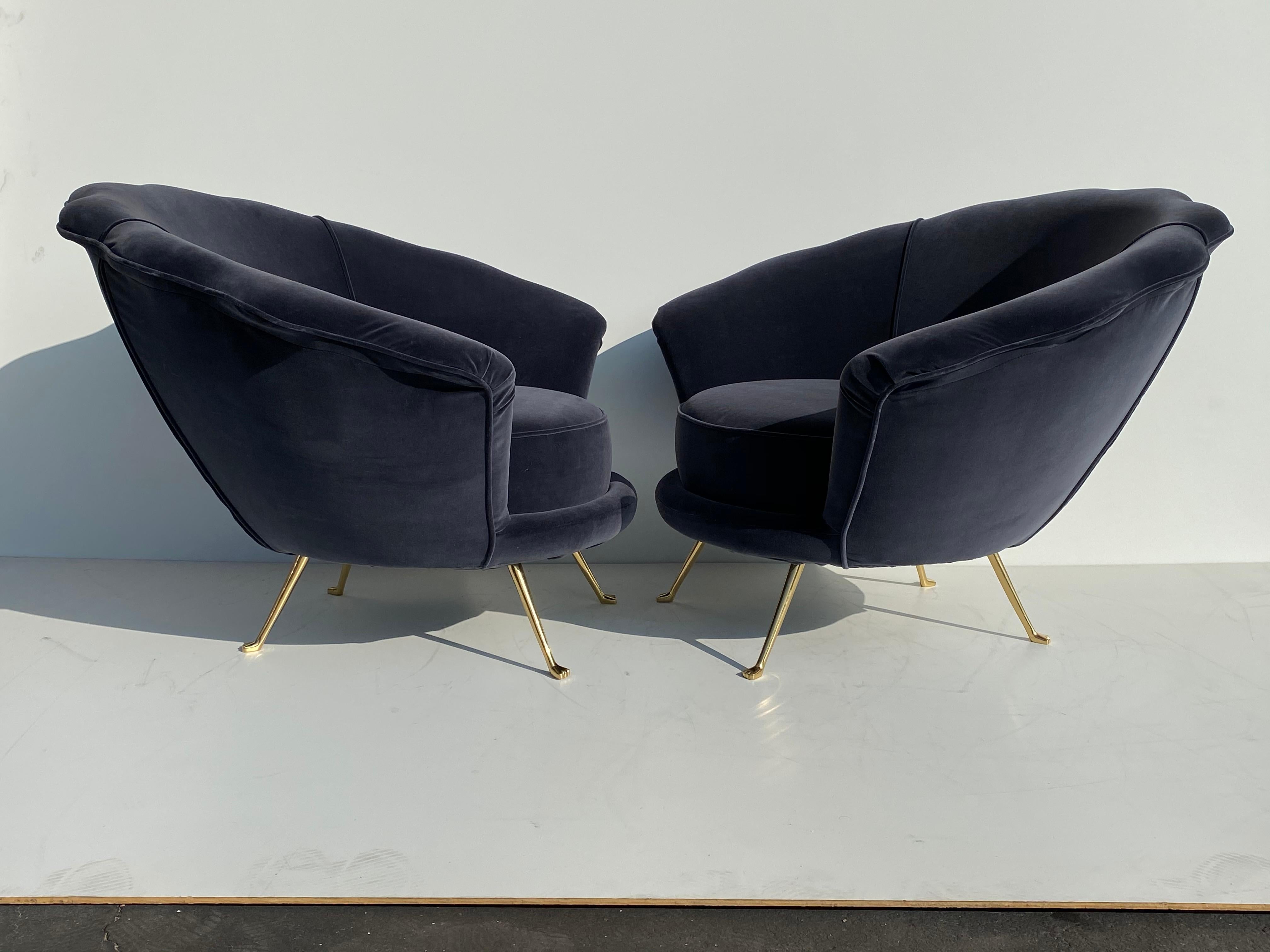 Pair of scalloped back velvet lounge chairs with brass legs.