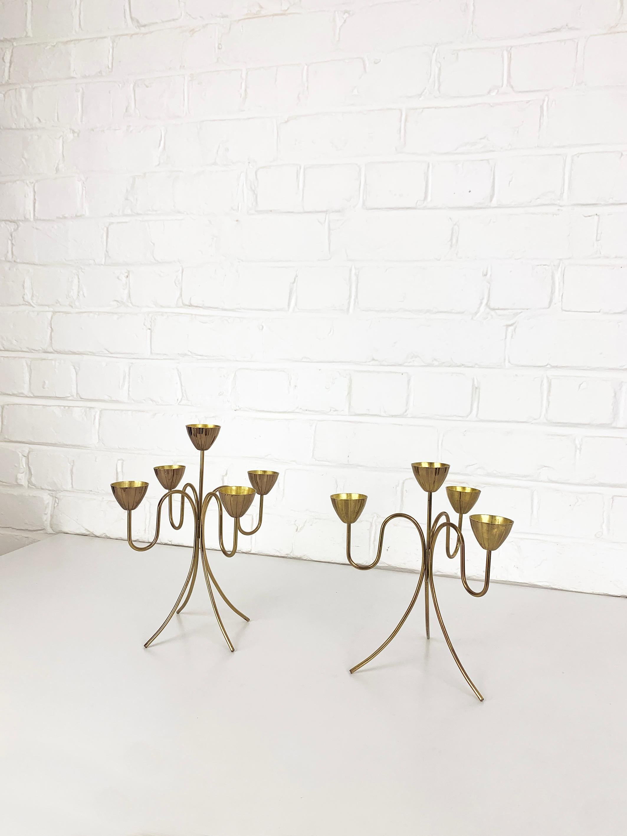 Paire de candélabres modernistes suédois par Gunnar Ander. Produit par Ystad-Metall, situé dans la ville d'Ystad en Suède. 

Bougeoirs en laiton massif poli. Design/One de quatre ou cinq fleurs stylisées qui sont placées sur une base formée par des