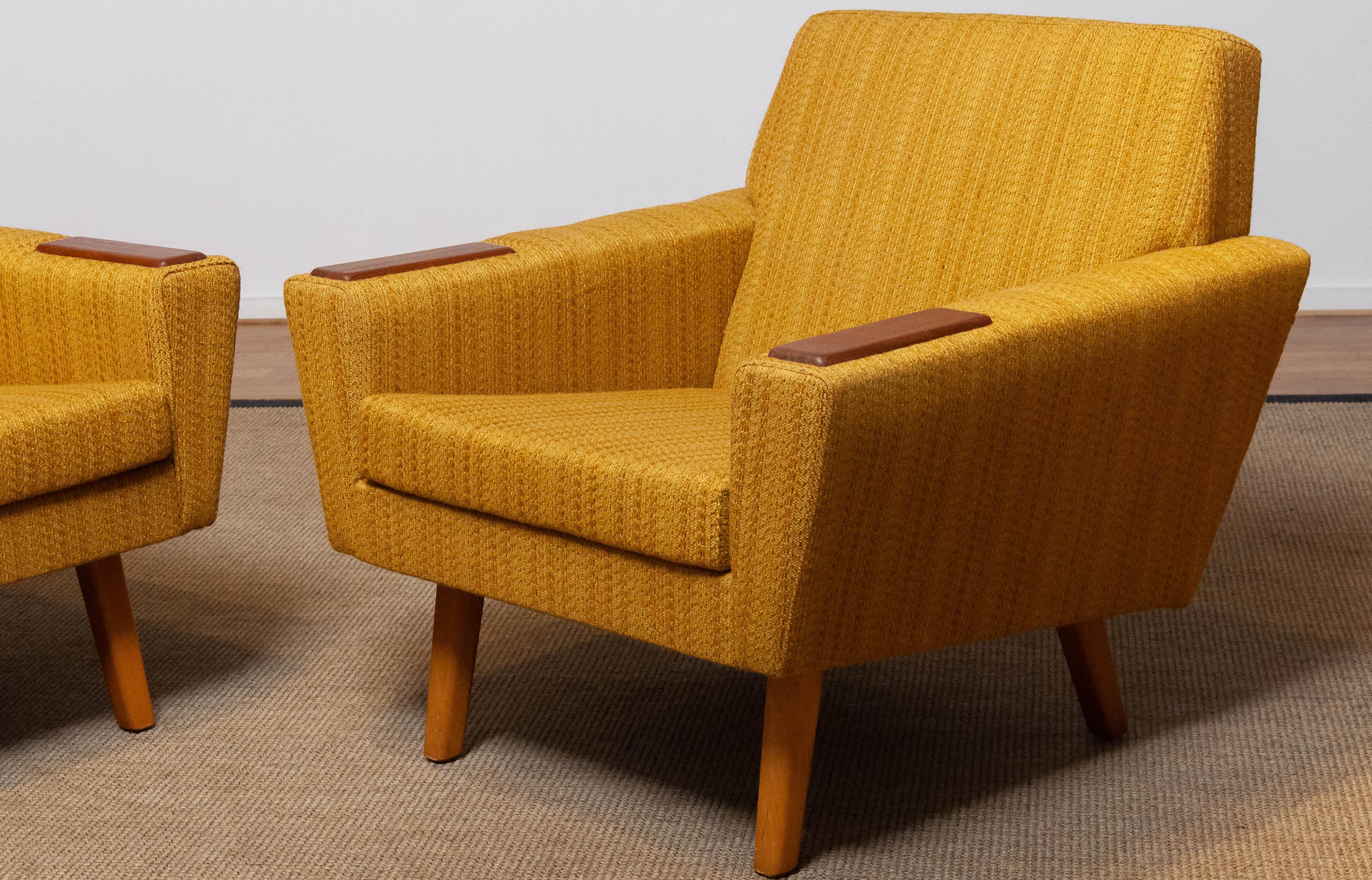 Pair of absolutely beautiful and typical Scandinavian mid century lounge chairs in yellow / ocher and a little brown blended colored woolen fabric in complete original condition. These chairs supports and sits very good and are in allover very good