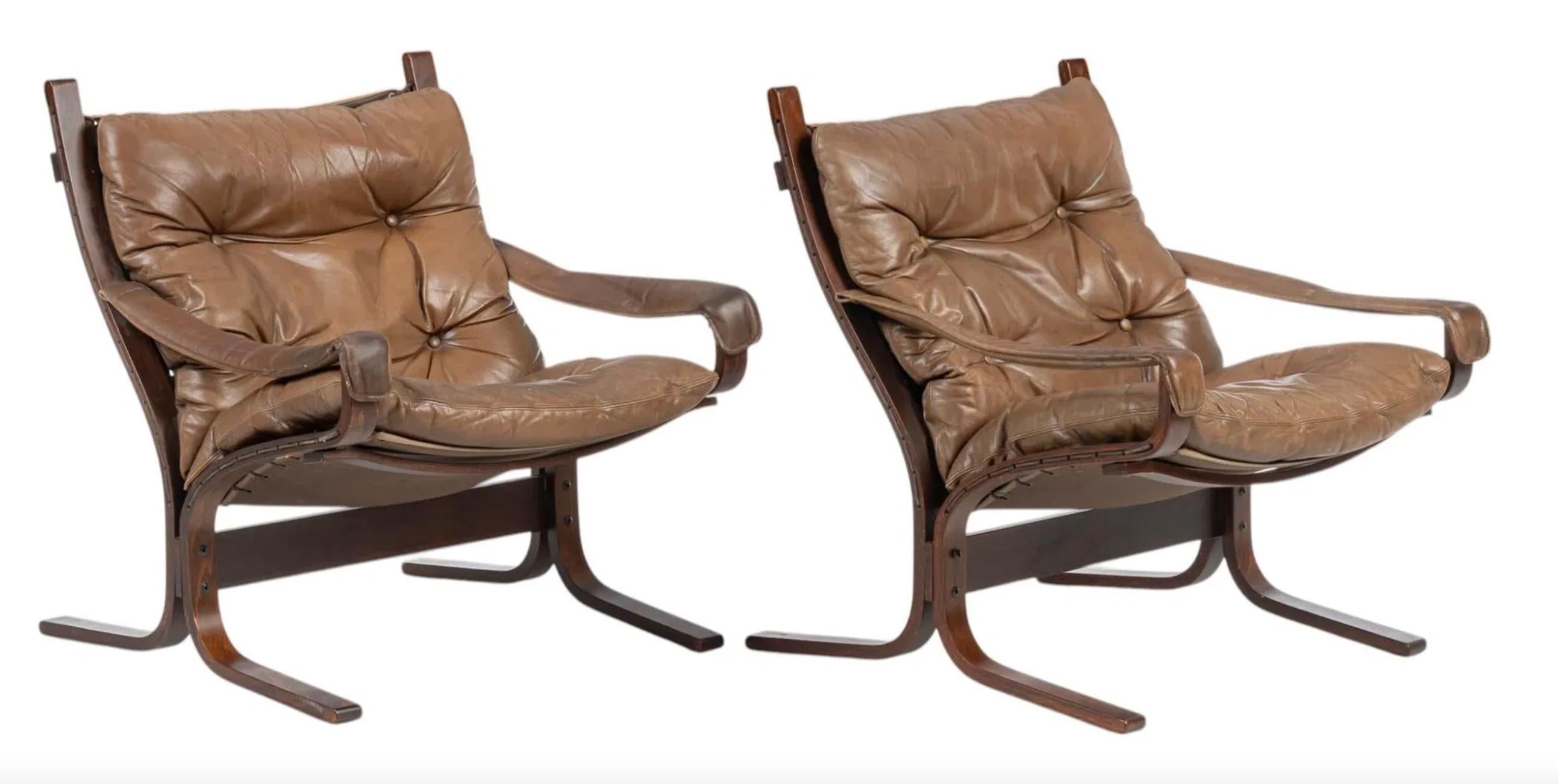 Pair of Westnofa Norwegian modern Low Siesta Safari chairs designed by Ingmar Relling. Dark Stained Beech Wooden frames, beautiful worn Tan leather cushions. Bentwood frames and Brown cloth sling backing. Westnofa Furniture label to underside