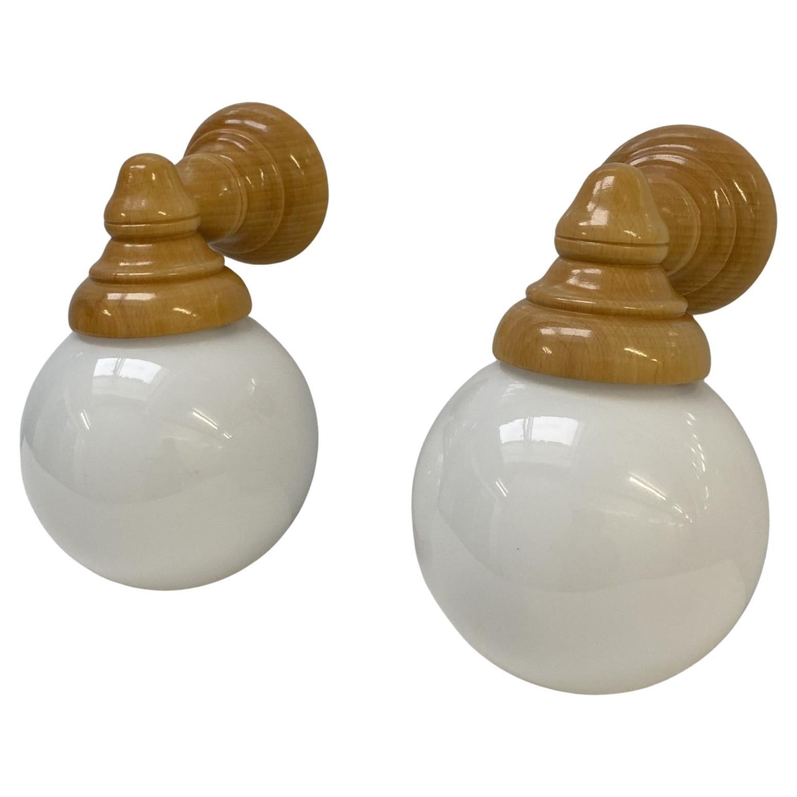 A lovely pair of Danish designer glazed pine wood wall sconces, Denmark, 1960s. Very elegant design with opaline glass shades. These wall lights can be mounted with the glass shade facing up or down (please also see pictures). Both wall lights in