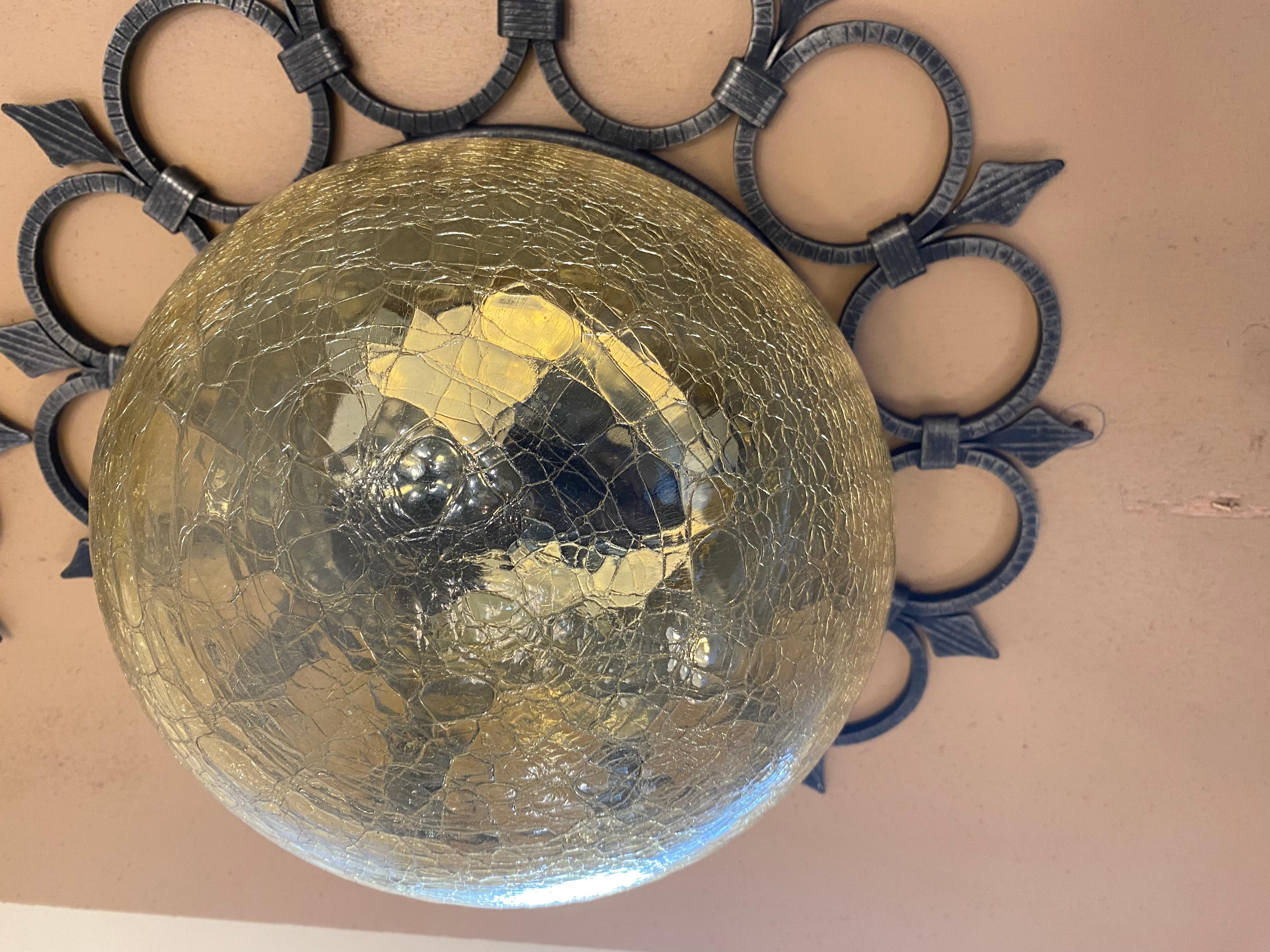 Pair of sconces from the 1960s, Italian origin. Structure in wrought iron and bubbled and cracked glass in golden yellow color representing a flower bud. Pair of sconces that can be placed on each side of a mirror or alone above a chest of drawers
