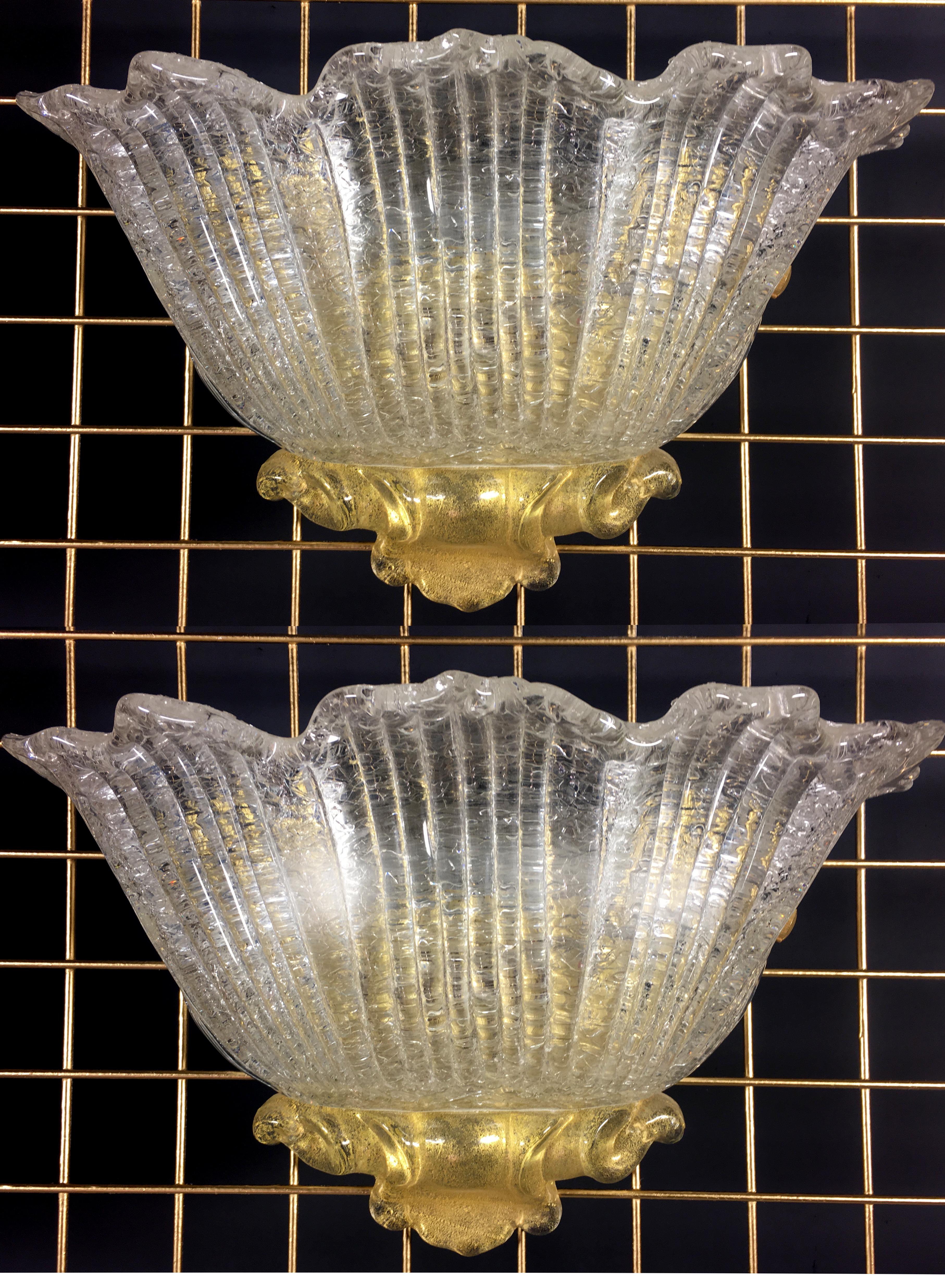 Luxurious pair of sconces in Murano glass with gold inclusions. To complete a modern atmosphere with refined taste.