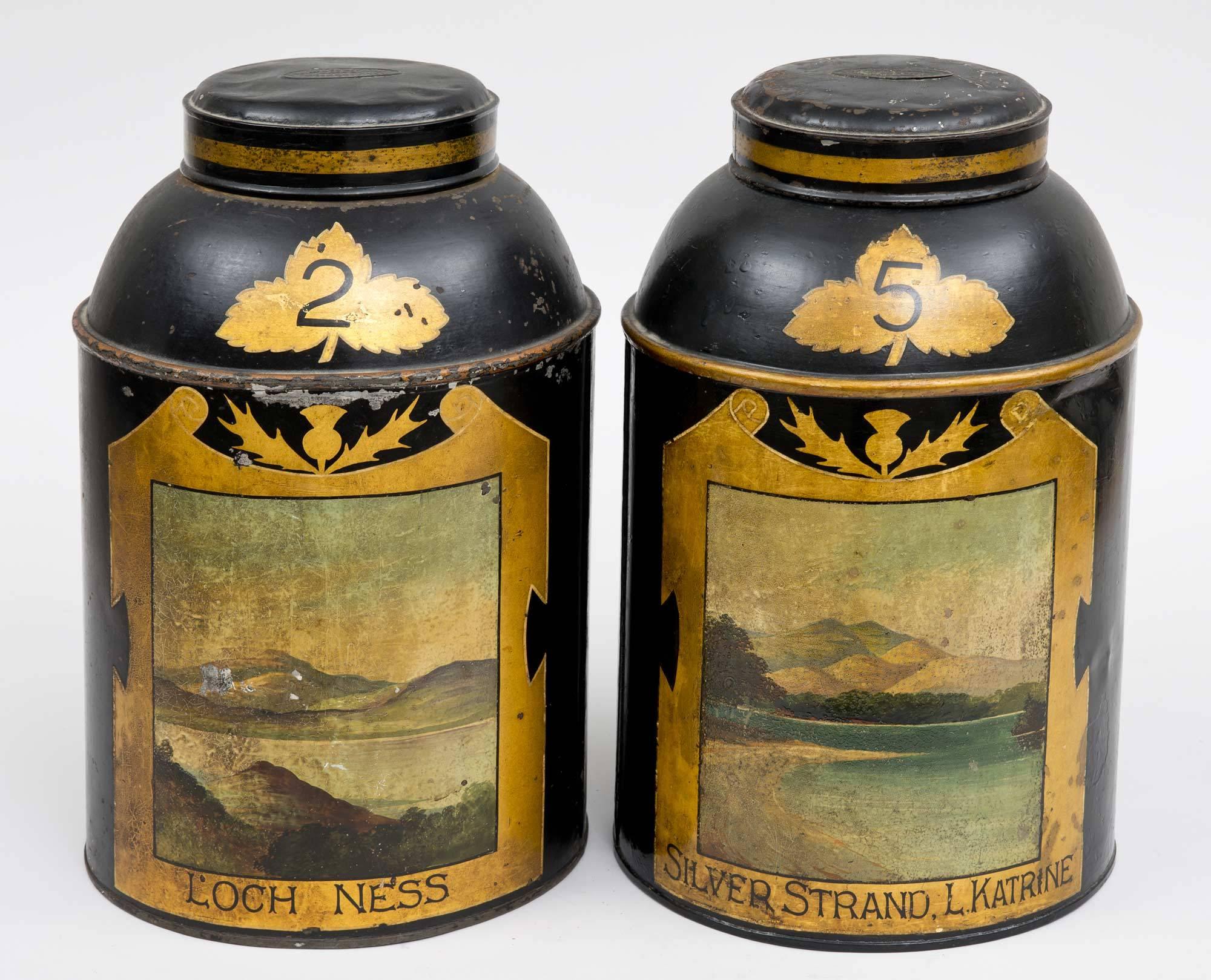 Pair of Scottish tole tea canisters, one with a view of Loch Ness within a gilded frame with a thistle at the top, marked 2; the other a view of Silver Strand, Loch Katrine, also within a gilded frame with a thistle at the top, marked 5. The label