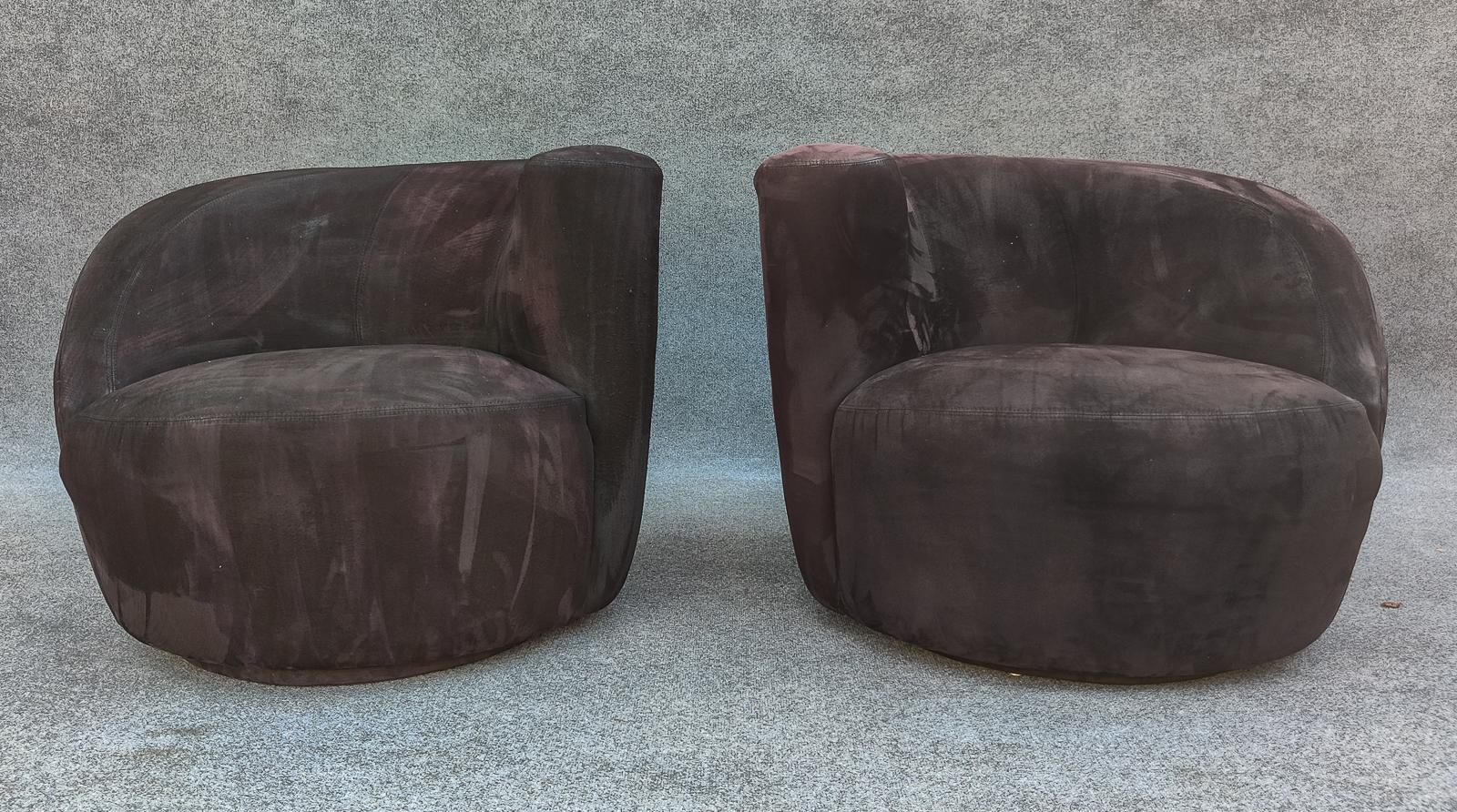 Reminiscent of the Nautilus chair, designed by Vladimir Kagan in 1950, here is a sculptural pair (left and right) of iconic mid-century modern swivel lounge chairs. Its distinct and organic design features a curved, shell-like shape made of suede
