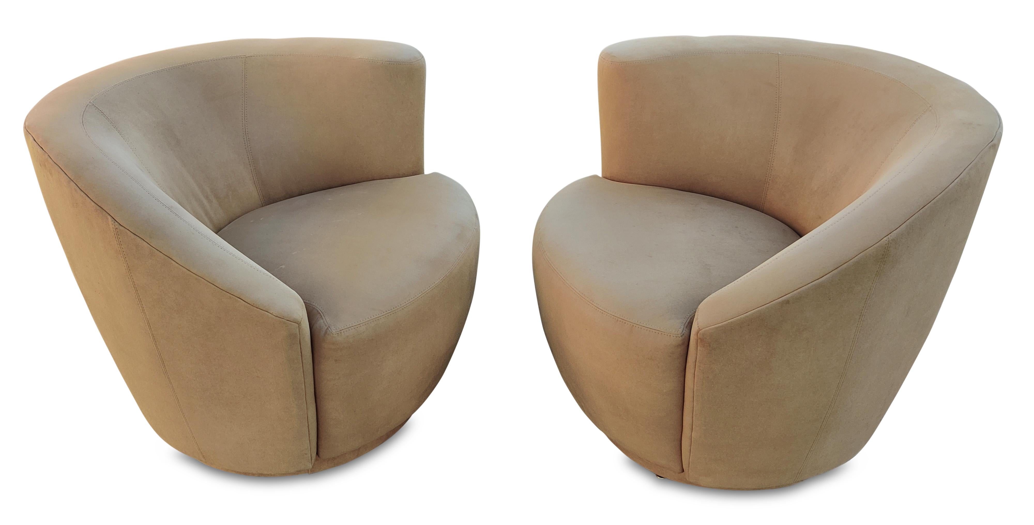 Reminiscent of the Nautilus chair, designed by Vladimir Kagan in 1950, here is a sculptural pair (left and right) of iconic mid-century modern swivel lounge chairs. Its distinct and organic design features a curved, shell-like shape made of suede