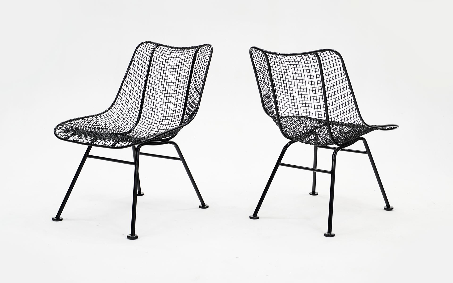 Two Woodard Sculptura armless dining chairs. Professionally media blasted and powder coated in a satin black finish. Woven wire and wrought iron construction. Designed by John Woodard and ofter misattributed to Russell Woodard.