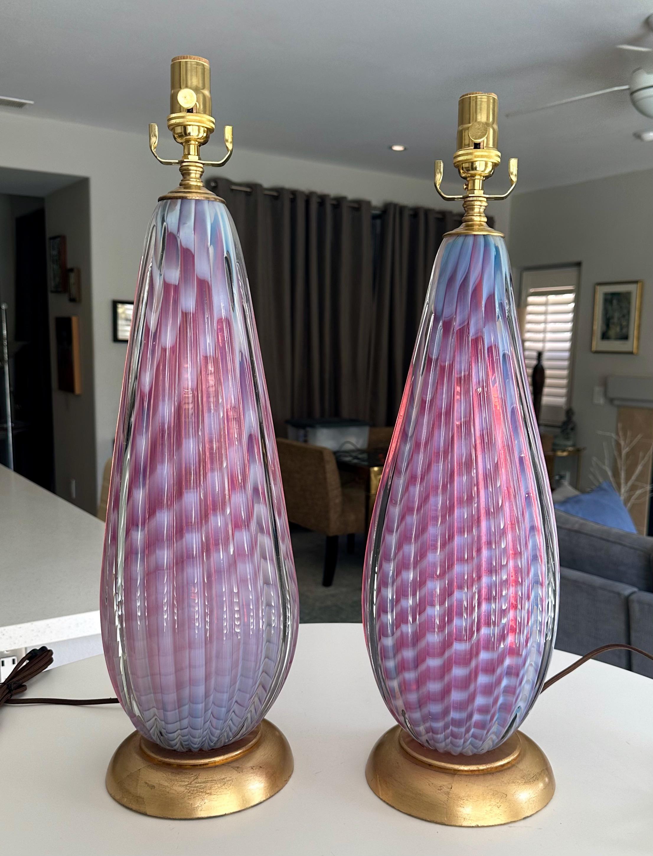 Pair handblown Italian Murano oval shaped striped lavender and fuchsia colored glass table lamps (called Opalina Rosa) by Seguso. The ribbed lamps are heavy and exceptionally well crafted. They rest on decorative antiqued gilt metal bases. Newly