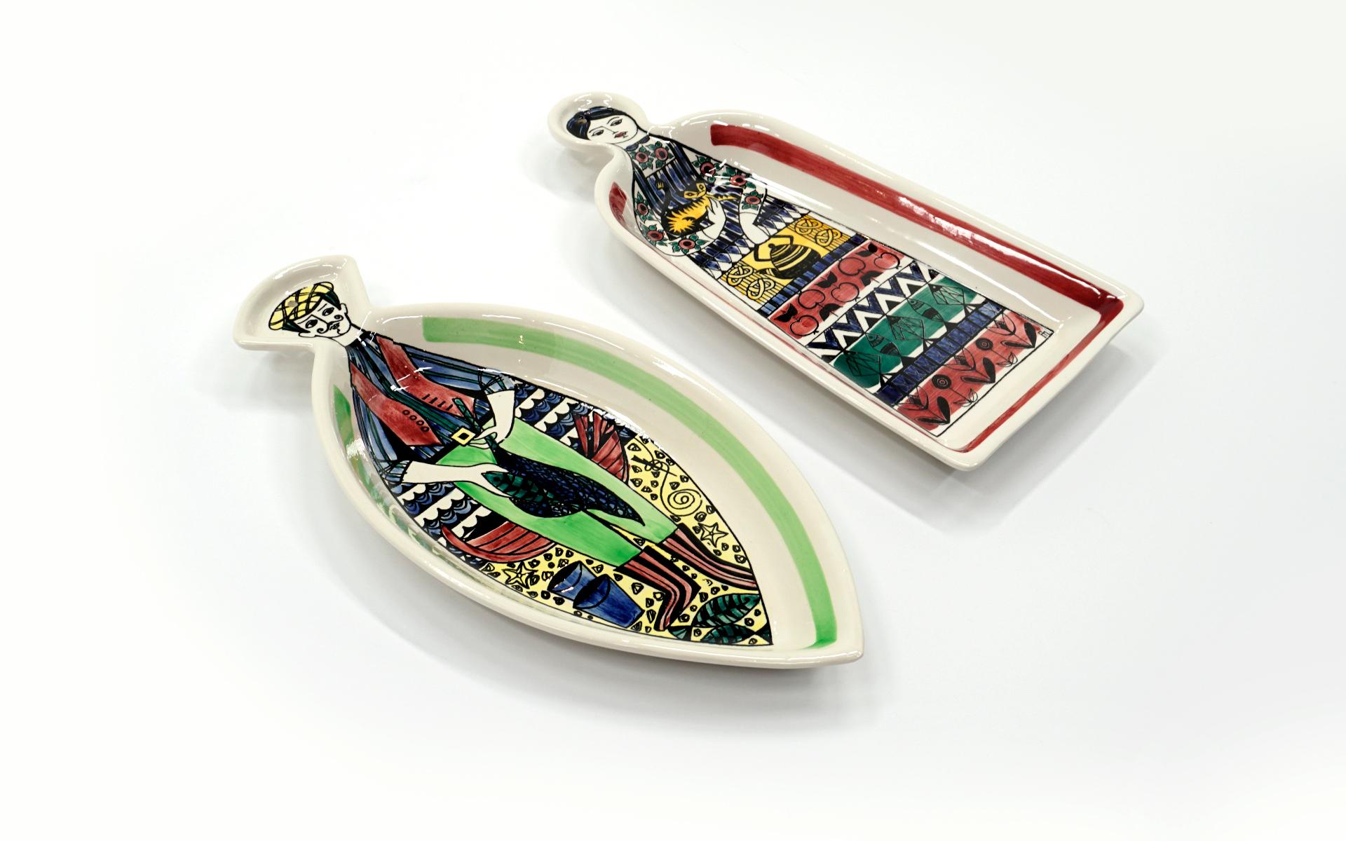 Colorful hand painted functional and decorative serving dishes in the shape of a fish and a bell with male and female figures. Suitable for hanging on the wall as these did for their entire existence. No chips, cracks or scratches. Designed by Anita