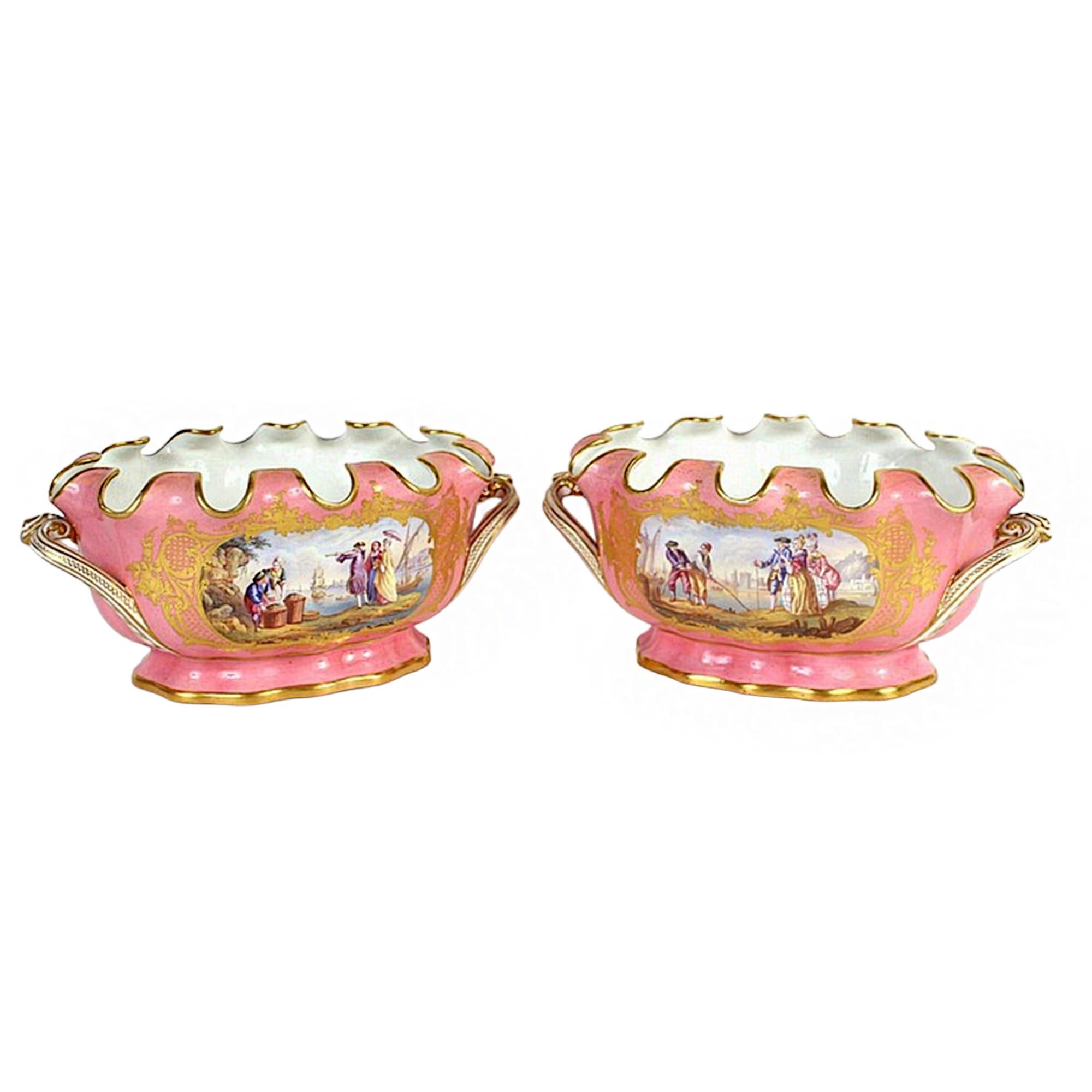 Gorgeous pair of Pink Cache Pots with figural scenes on either side. The scenes depict merchants selling their wares to a nobleman at a market by the water, with large cargo ships floating by. The pots' rippled edges allows for the creation of full