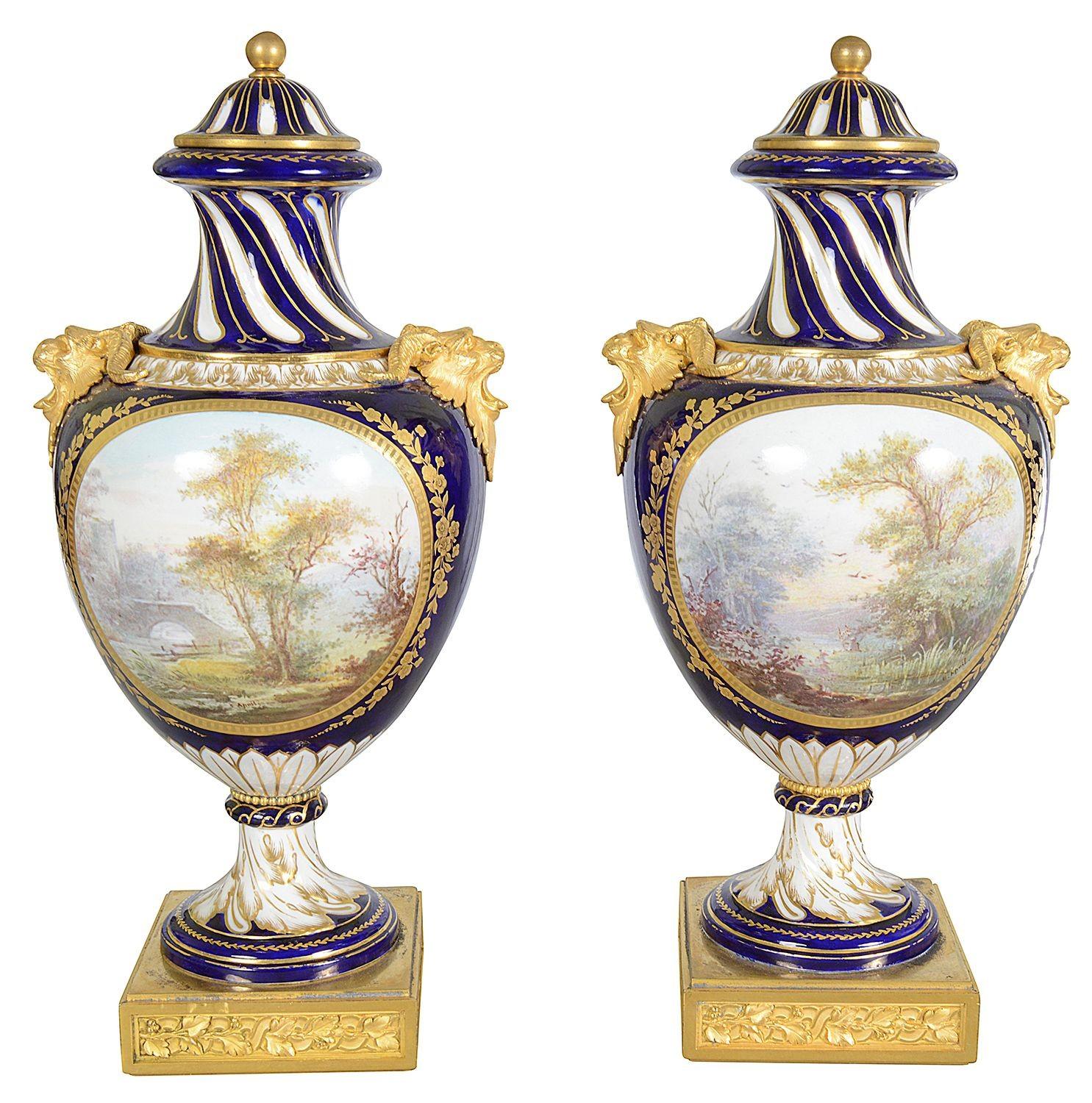 Coppia di vasi con coperchio in porcellana francese di Sèvres della fine del XIX secolo, molto decorativi e di qualità. Ciascuna di esse presenta un fondo blu cobalto, decorazioni a volute dorate, terminali in ormolu, maniglie a testa di martello e