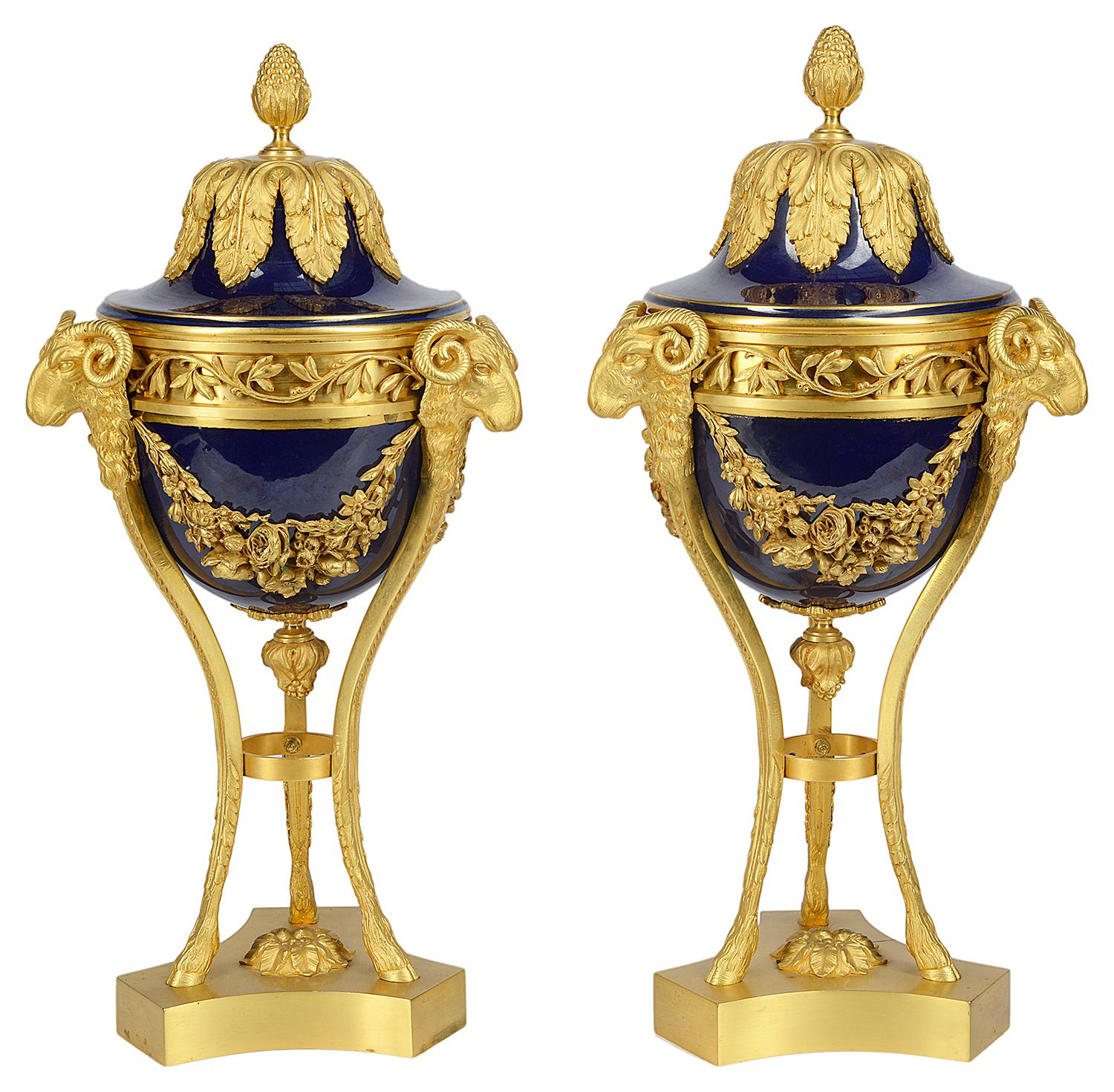 A good quality pair of early 20th century Sevres style lidded porcelain and gilded ormolu mounts. Each with classical foliate, swag and ram's head detail and raised on hoof feet.