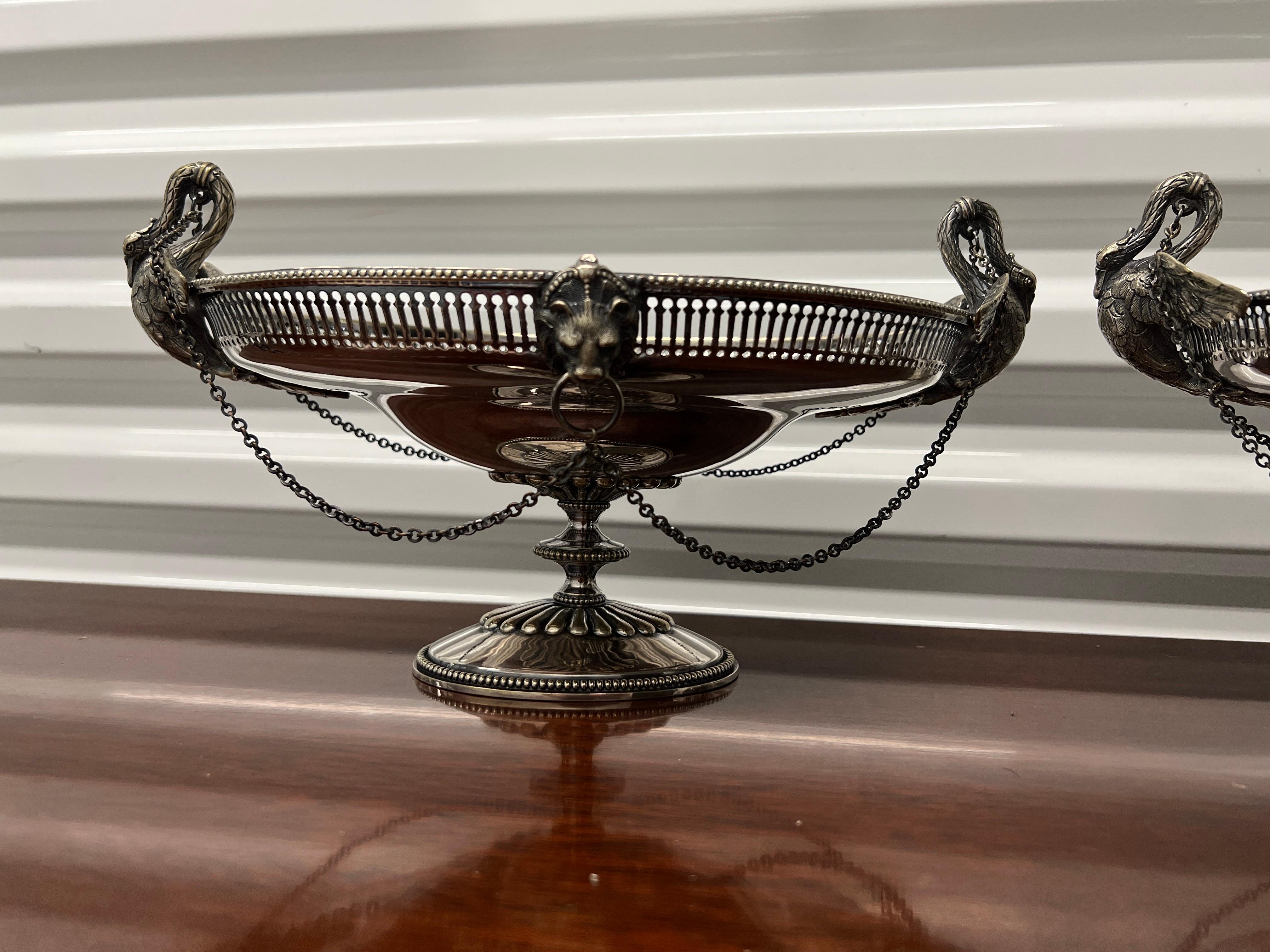 English, circa 1862.

A pair of good quality antique Sheffield made silverplate pedestal baskets. Each basket has a pierced frame, lion head mounts to front and verso and flanked by swan motif handles to either side. A strange and unique series of