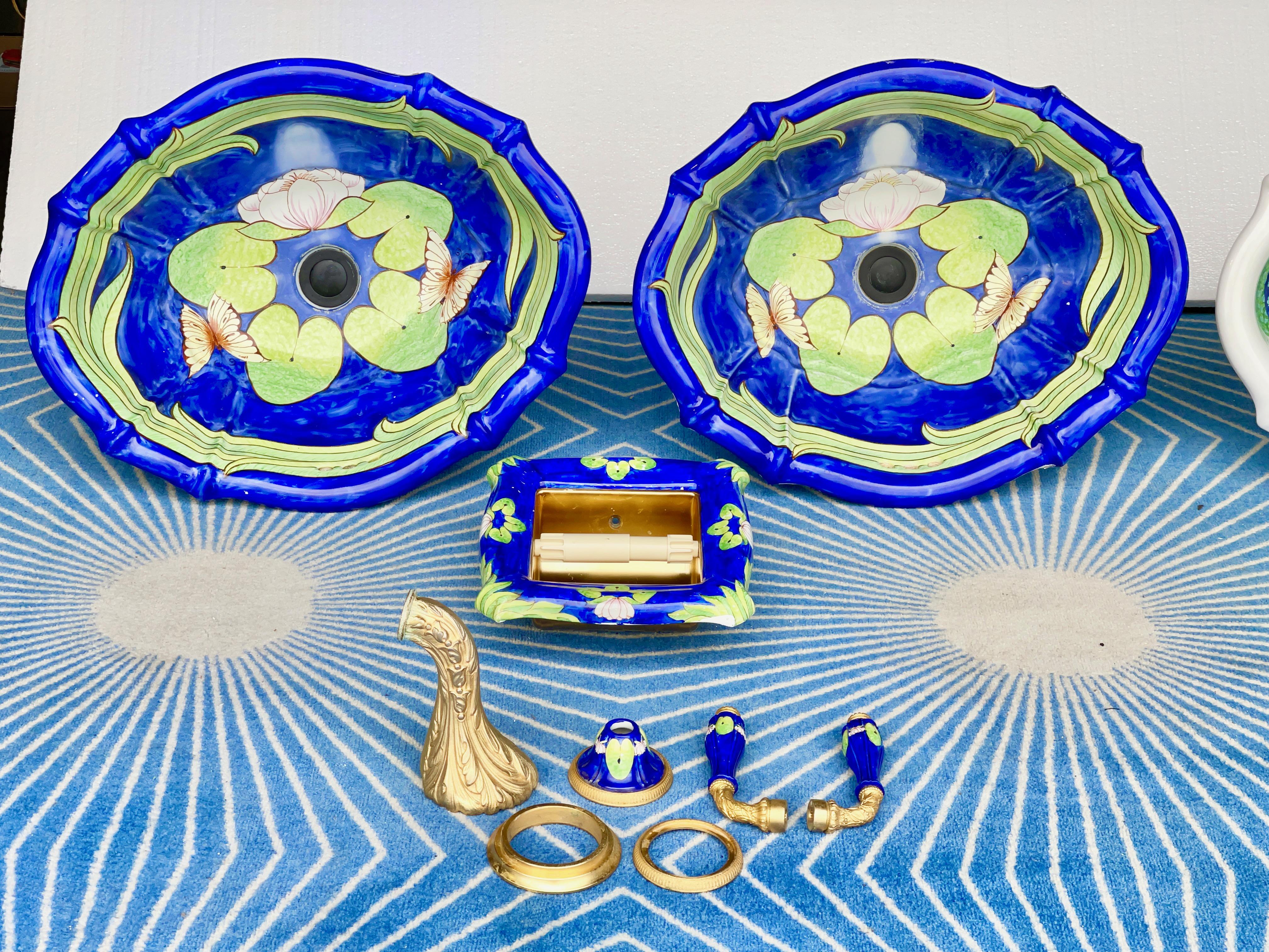 Paire d'éviers assortis en porcelaine italienne peinte à la main par Sherle Wagner, avec un motif de fleurs de lotus, une forme ovale festonnée, un bord surélevé et un insert de comptoir.
Labellisé à la porcelaine : Sherle Wagner Italie.
Drainage